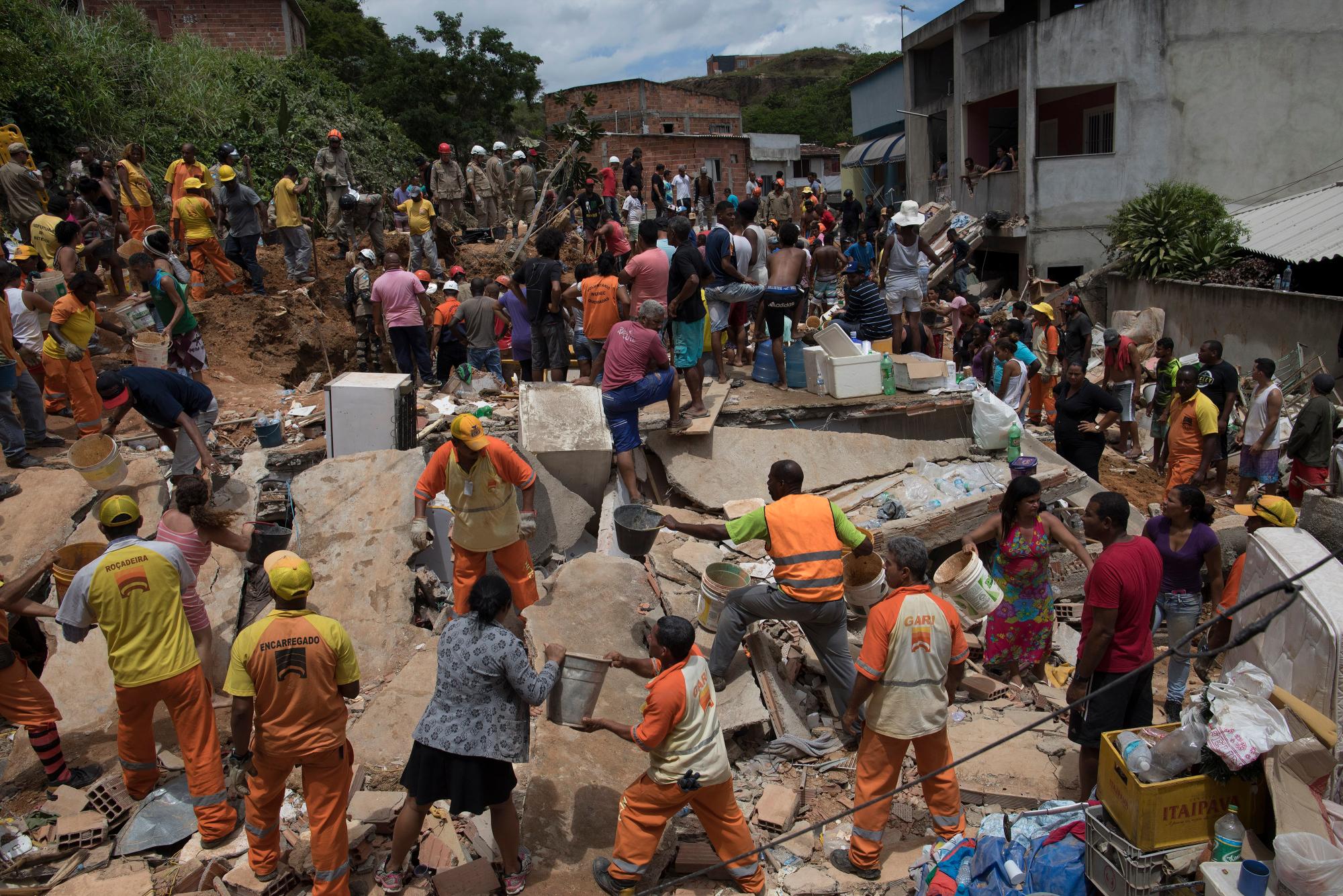 Residentes, voluntarios y bomberos trabajan sobre los escombros después de un deslizamiento de lodo en Boa Esperanca o en la barriada “Good Hope” en Niteroi, Brasil, el sábado 10 de noviembre de 2018.