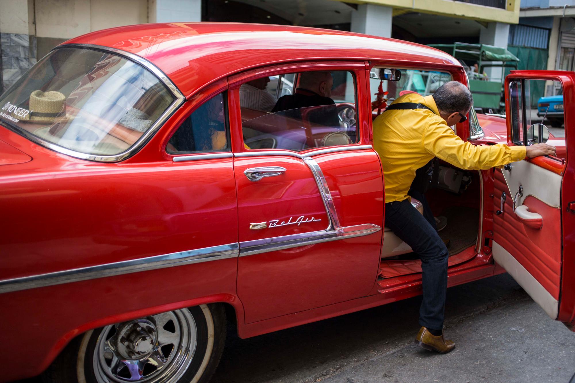 Un pasajero aborda un Chevrolet Bel Air de 1955 que aún funciona como taxi colectivo en La Habana, Cuba, viernes 16 de noviembre de 2018. Cientos de autos clásicos se reunirán cerca del Malecón para honrar a este grupo único de vehículos, uno de los más importantes de Cuba. emblemas Miles de estos autos de 1930 a 1960 continúan trabajando hoy en las calles de Cuba.