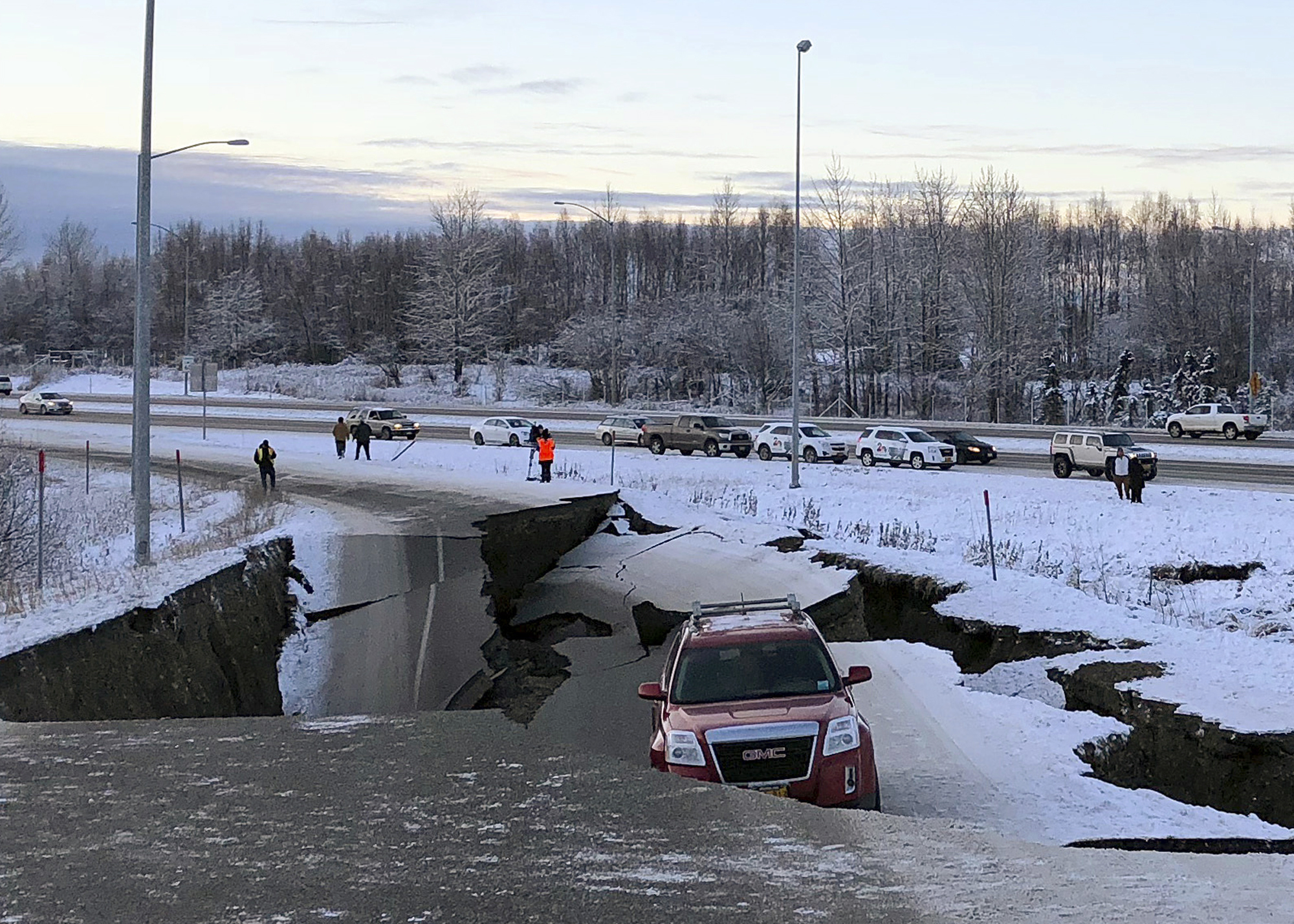 Un automóvil está atrapado en una sección colapsada de la rampa de salida de Minnesota Drive en Anchorage, el viernes 30 de noviembre de 2018.