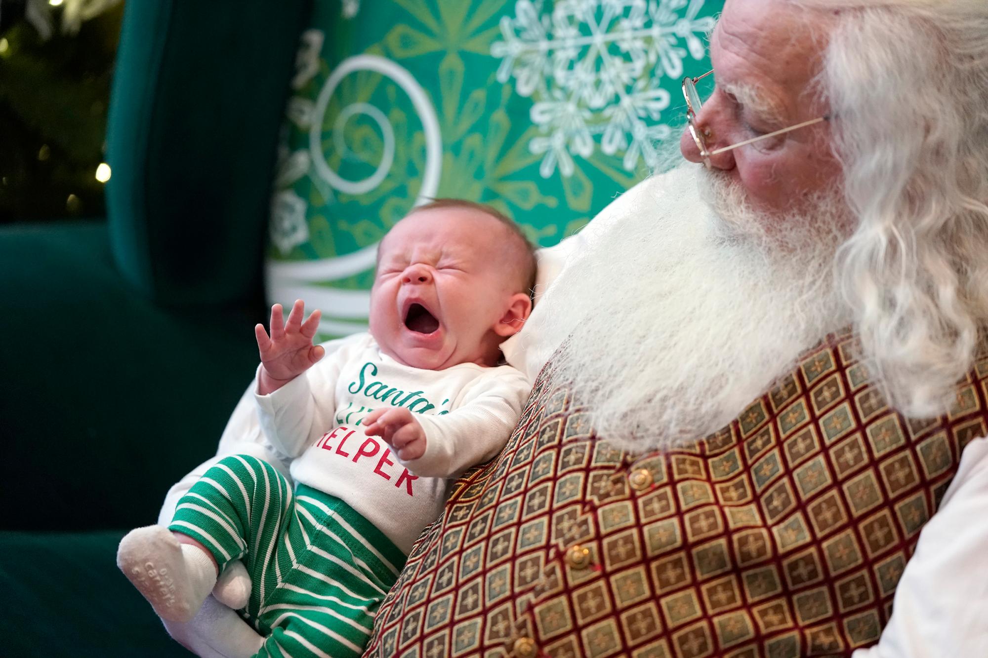 Liam Larson de Plymouth, de tres semanas de edad, bosteza mientras estaba en los brazos de Santa en el Southdale Center en Edina, Minnesota.