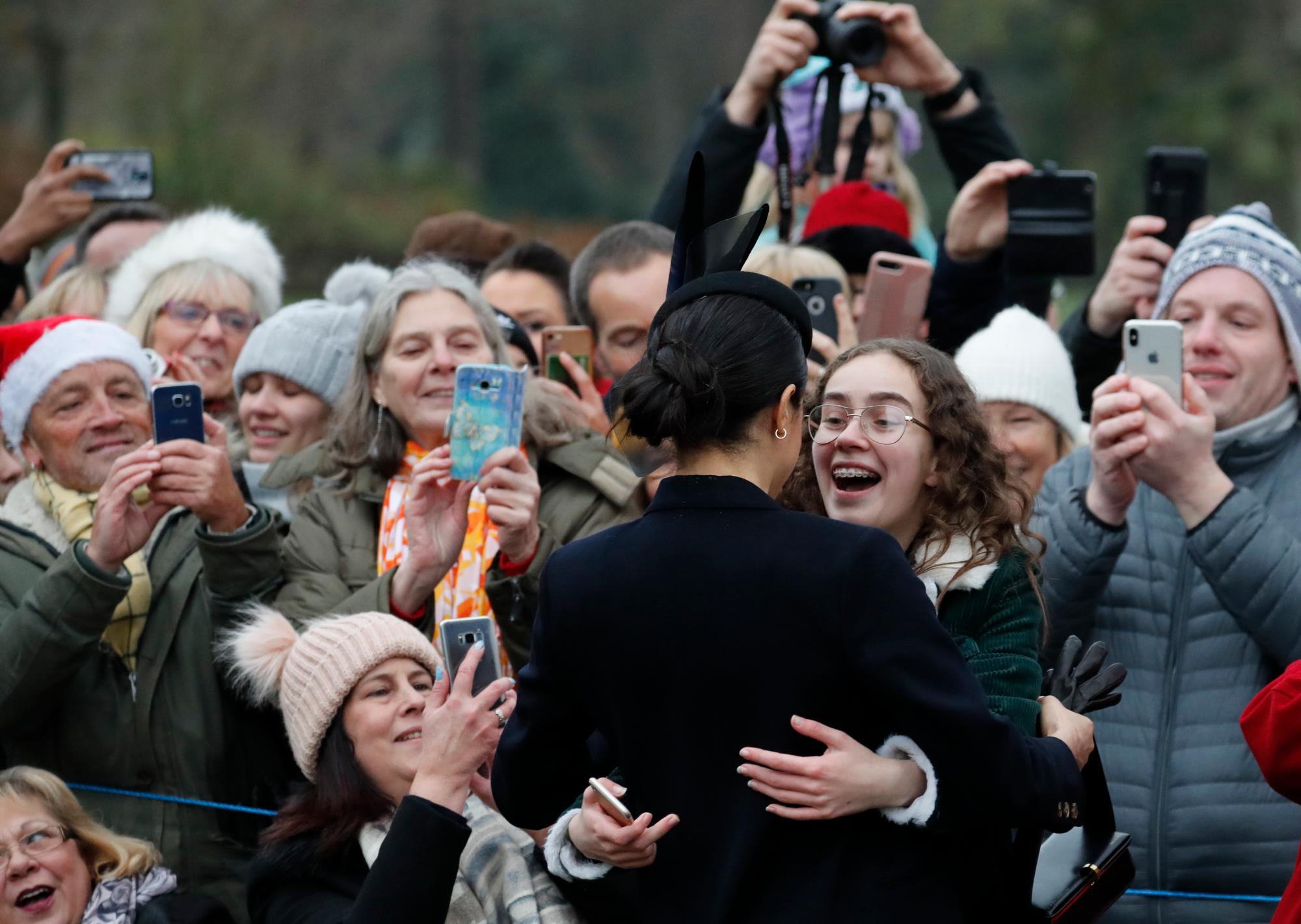 Meghan de Gran Bretaña, Duquesa de Sussex recibe un abrazo de una de los miembros de la multitud después de asistir al servicio de Navidad en la iglesia de Santa María Magdalena en Sandringham en Norfolk, Inglaterra.