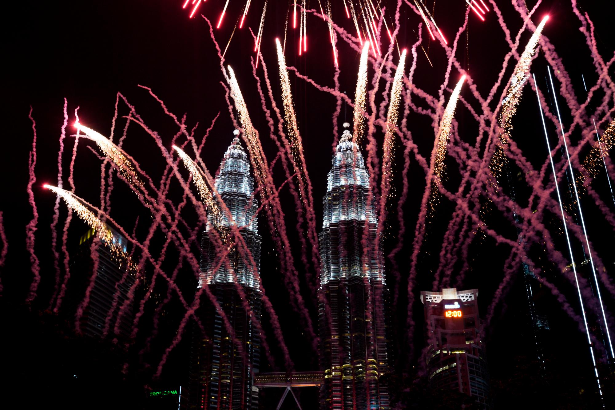Los fuegos artificiales frente al edificio emblemático de Malasia, las Torres Petronas, durante la celebración de Año Nuevo en Kuala Lumpur, Malasia, el martes 1 de enero de 2019. 