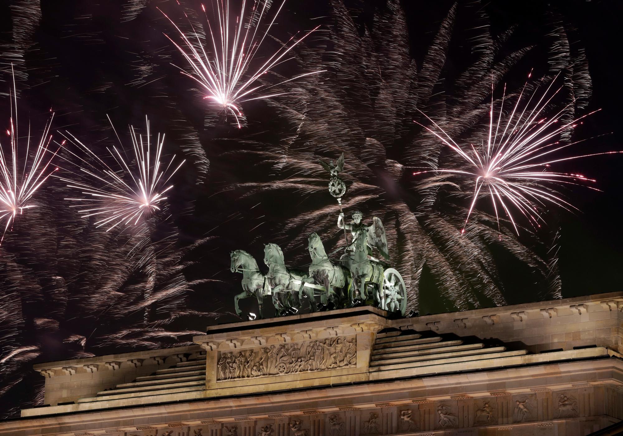 Los fuegos artificiales iluminan el cielo sobre la Cuadriga en la Puerta de Brandeburgo poco después de la medianoche en Berlín, Alemania, el martes 1 de enero de 2019. Cientos de miles de personas celebraron la víspera de Año Nuevo dándole la bienvenida al nuevo año 2019 en la capital de Alemania.