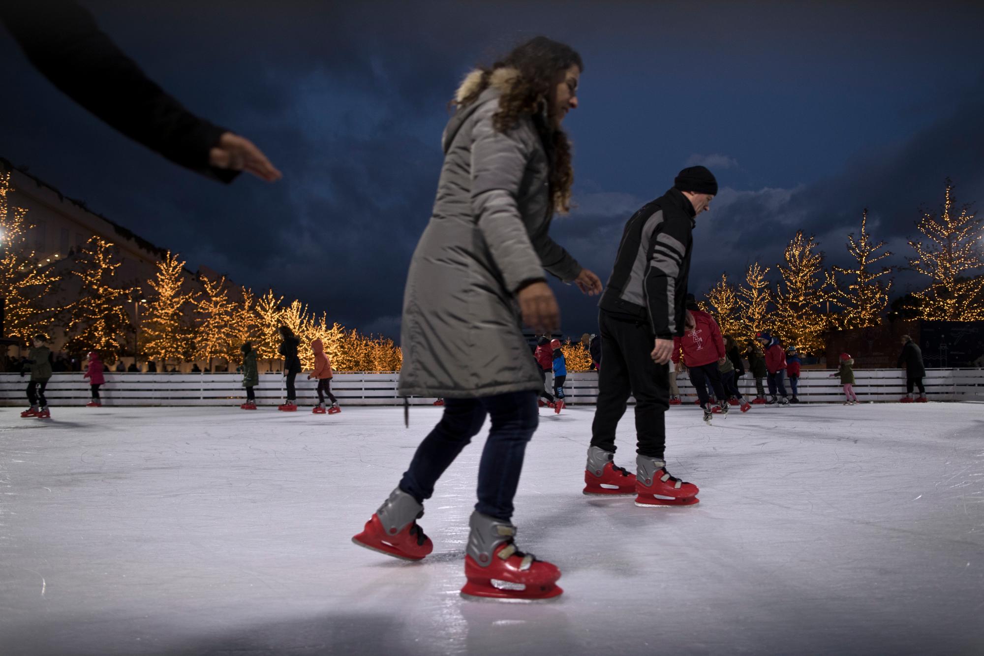 La gente disfruta de patinar sobre hielo en una pista durante el primer día del año en el Centro Cultural de la Fundación Stavros Niarchos en Atenas, el martes 1 de enero de 2019.