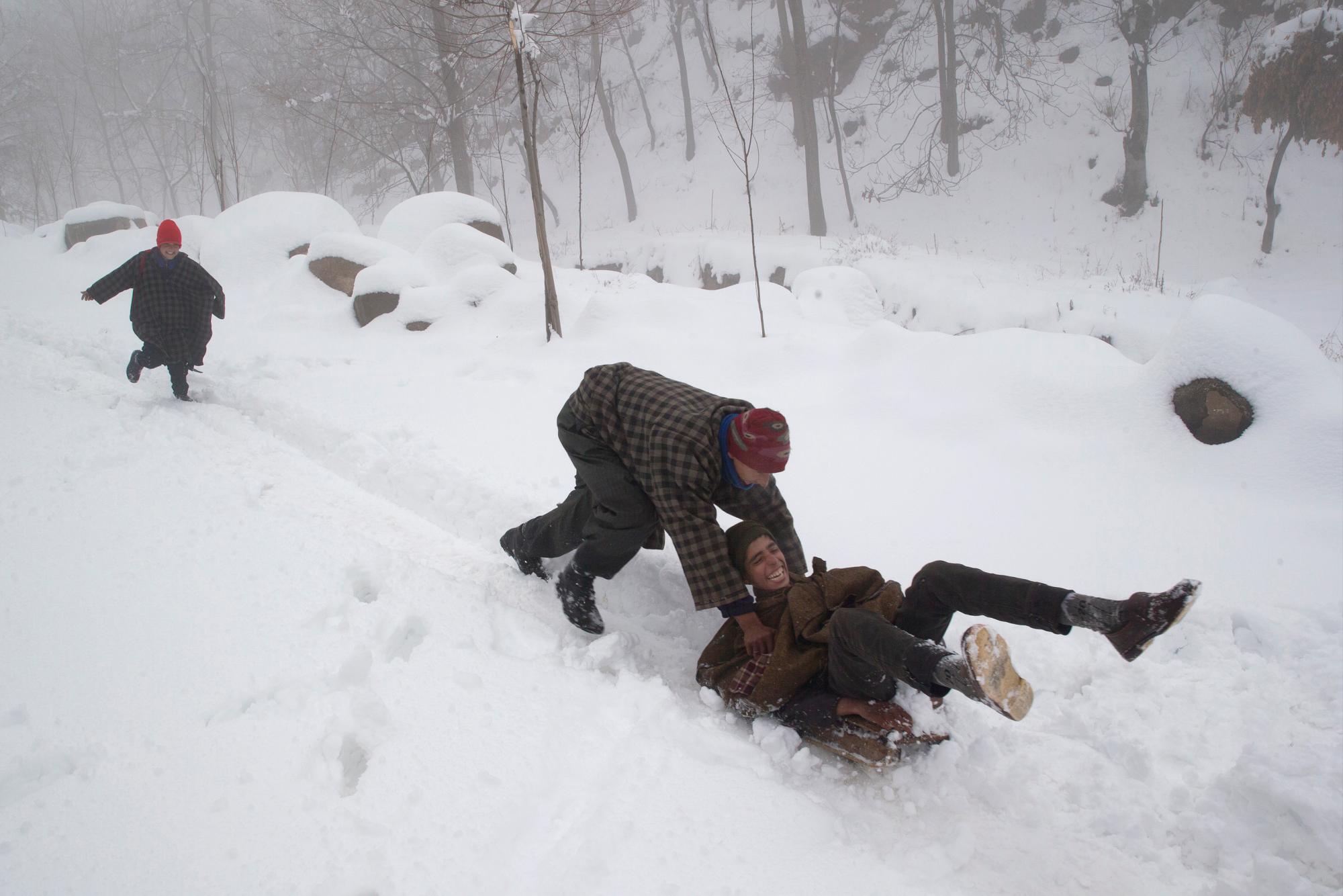 Los niños de Cachemira disfrutan de un trineo en una pendiente cubierta de nieve después de un período de nevadas frescas en las afueras de Srinagar, Cachemira controlada por los indios, el sábado 5 de enero de 2019. La región de Cachemira ha estado experimentando nieve durante unos días, lo que ha provocado una interrupción del aire. Tráfico y tráfico entre Srinagar y Jammu, las capitales de verano e invierno del estado problemático de la India.