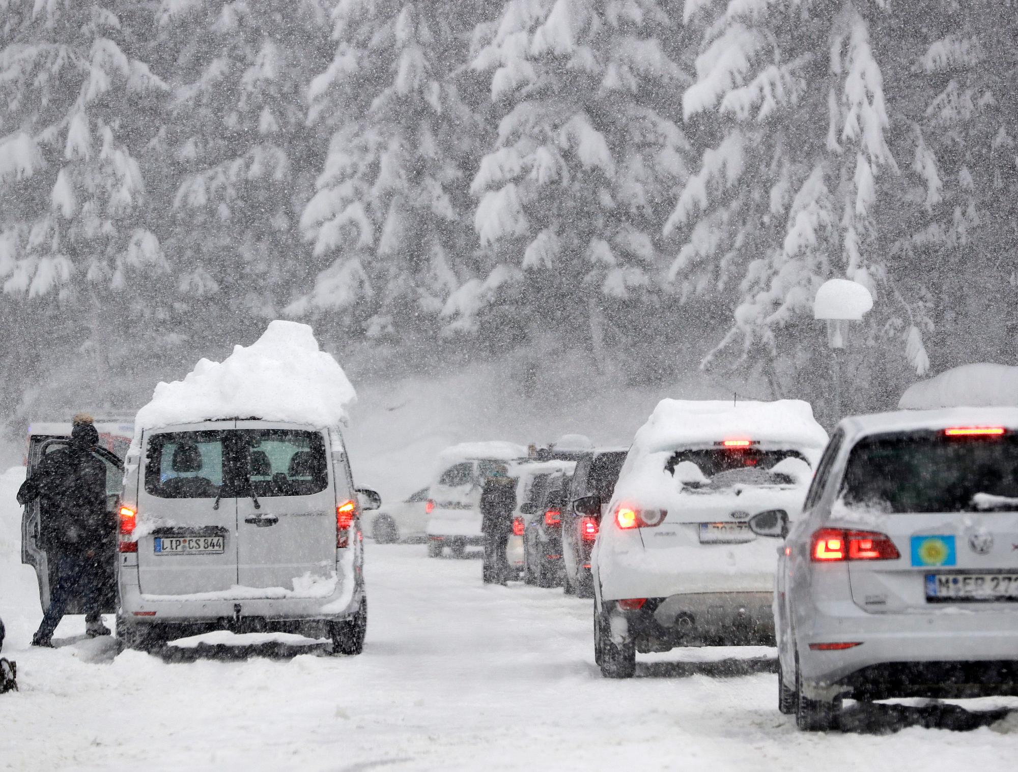 Los automóviles turísticos hacen cola en la carretera principal que sale de un valle que fue bloqueado luego de la nevada en Filzmoos, Austria, sábado 5 de enero de 2019.