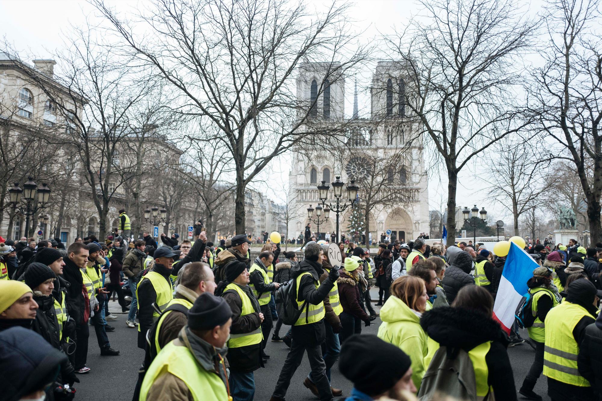 Los manifestantes vistiendo chalecos amarillos marchan durante una protesta en París, el sábado 5 de enero de 2019. Cientos de manifestantes intentaban dar nueva vida al movimiento de chalecos amarillos aparentemente menguantes de Francia con marchas en París y reuniones en otras ciudades. La catedral de Notre Dame al fondo.