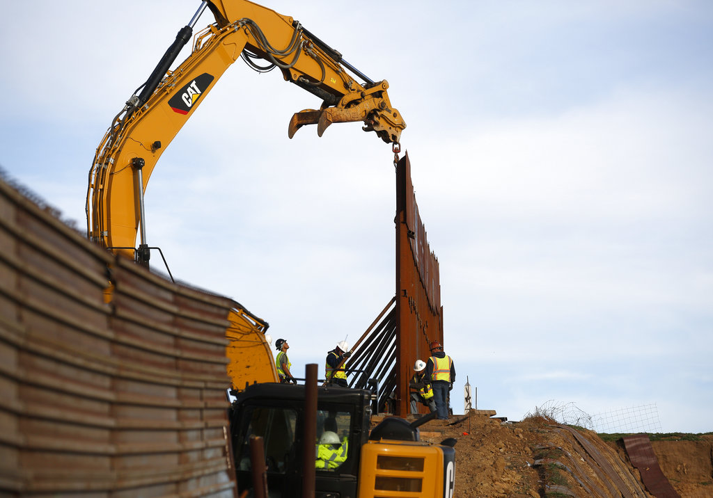 Los trabajadores reemplazan las secciones del muro fronterizo, a la izquierda, con nuevas secciones, a la derecha, el martes 8 de enero de 2019, en Tijuana, México. 