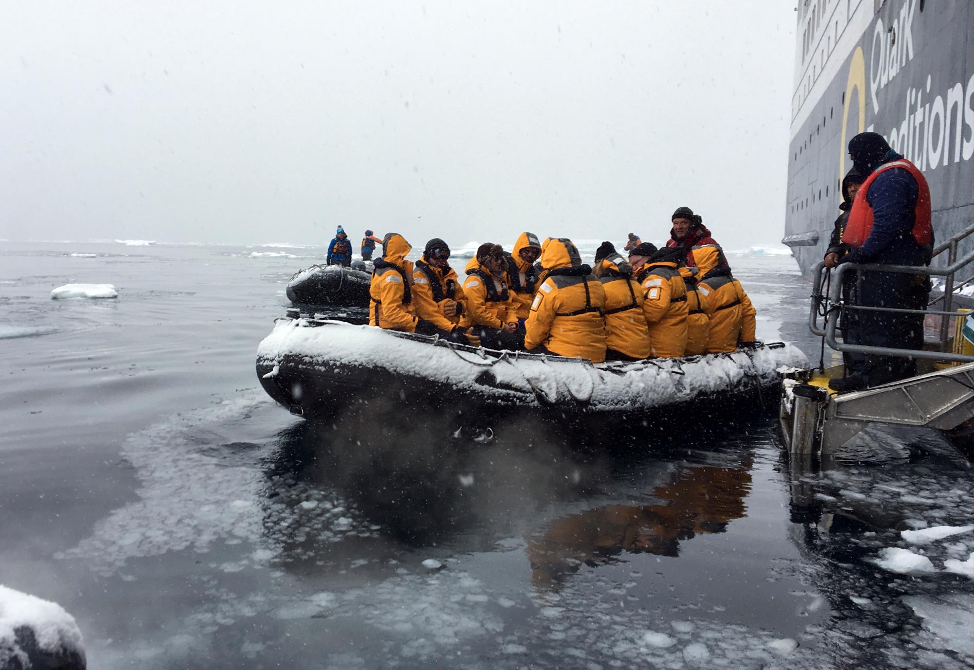 In this Dec. 7, 2018, photo provided by Wayne Dunn, tourists aboard a Zodiak raft prepare for the ride to shore on the Western Peninsula of Antarctica. Forty educators participated in the 2018 class of Grosvenor Teacher Fellows, a program that leads visits to the Antarctic area of the globe and the Galapagos Islands for the ultimate hands-on experience in professional development. (Wayne Dunn via AP)