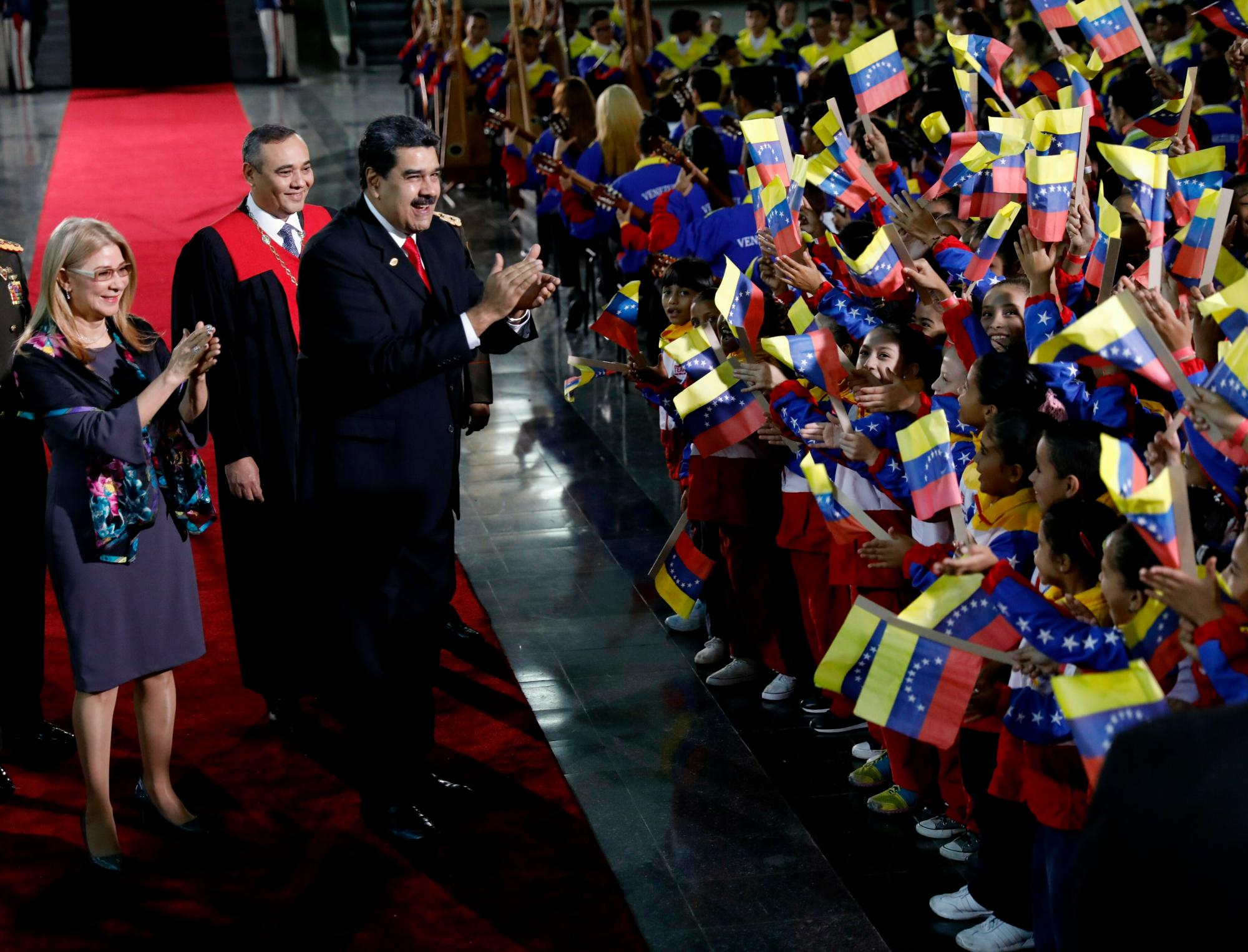 El presidente de Venezuela, Nicolás Maduro, y la primera dama, Cilia Flores, se detienen para saludar a los niños que están en la bandera y llegar a la ceremonia de juramentación en el Tribunal Superior de Justicia en Caracas, Venezuela, el jueves 10 de enero. de 2019.