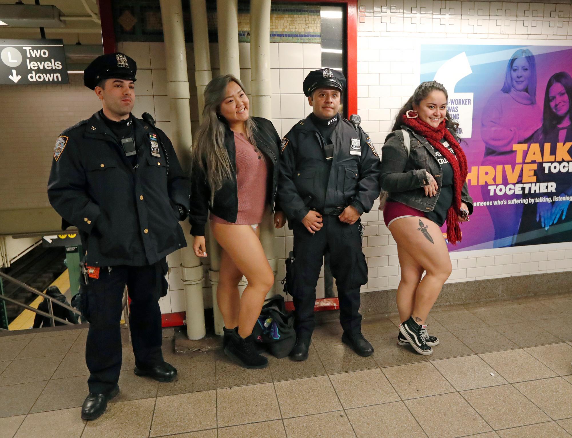 Dos mujeres posan para una fotografía con un par de oficiales de la policía de la ciudad de Nueva York en la estación de Union Square en la culminación de la 18va edición anual del viaje en metro de No Pants en Nueva York.