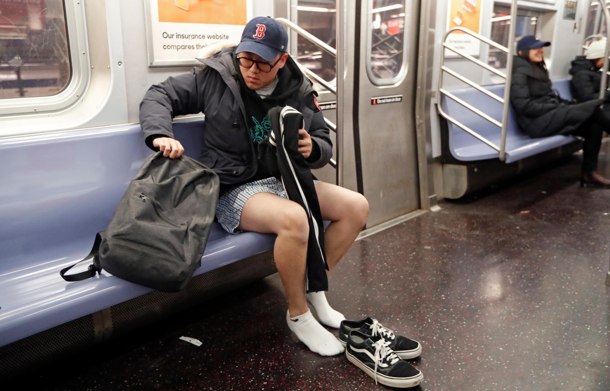 Un participante en la 18a edición anual de No Pants Subway Ride se quita los pantalones en el E Train, en Nueva York. La broma anual comenzó en Nueva York, pero ahora se realiza en varias ciudades del mundo. Los únicos dos requisitos para participar son que las personas estén dispuestas a quitarse los pantalones en el metro y no les digan nada.