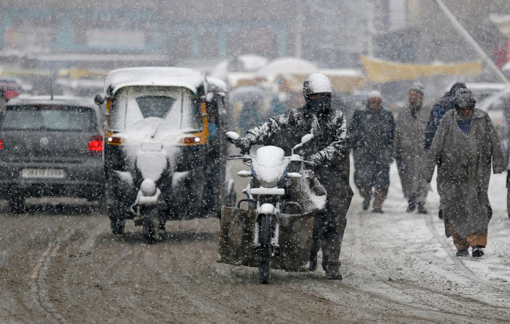 Los viajeros de Kashmiri se van al trabajo cuando cae nieve fresca en Srinagar, Kashmir, controlada por los indios, el miércoles 16 de enero de 2019. Las nevadas en la parte india de Kashmir han interrumpido el tráfico aéreo, y el tráfico por carretera entre Srinagar y Jammu, las capitales de verano e invierno de El estado de Jammu-Cachemira de la India, según informes de prensa.