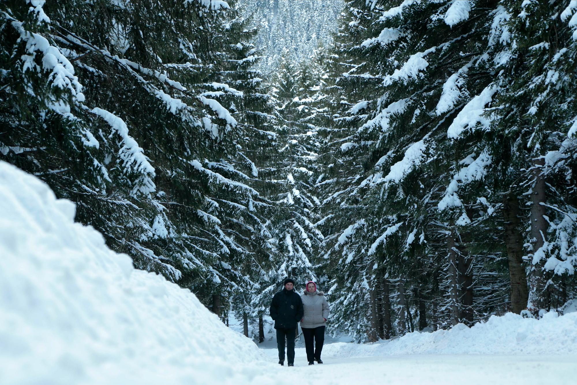 Gente bosnia que camina en una calle cubierta de nieve en la montaña de Jahorina cerca de Sarajevo, Bosnia, miércoles 16 de enero de 2019. Fueron nevadas en los países balcánicos que causaron estragos en el tráfico y el estado o la emergencia declarada en algunas áreas.