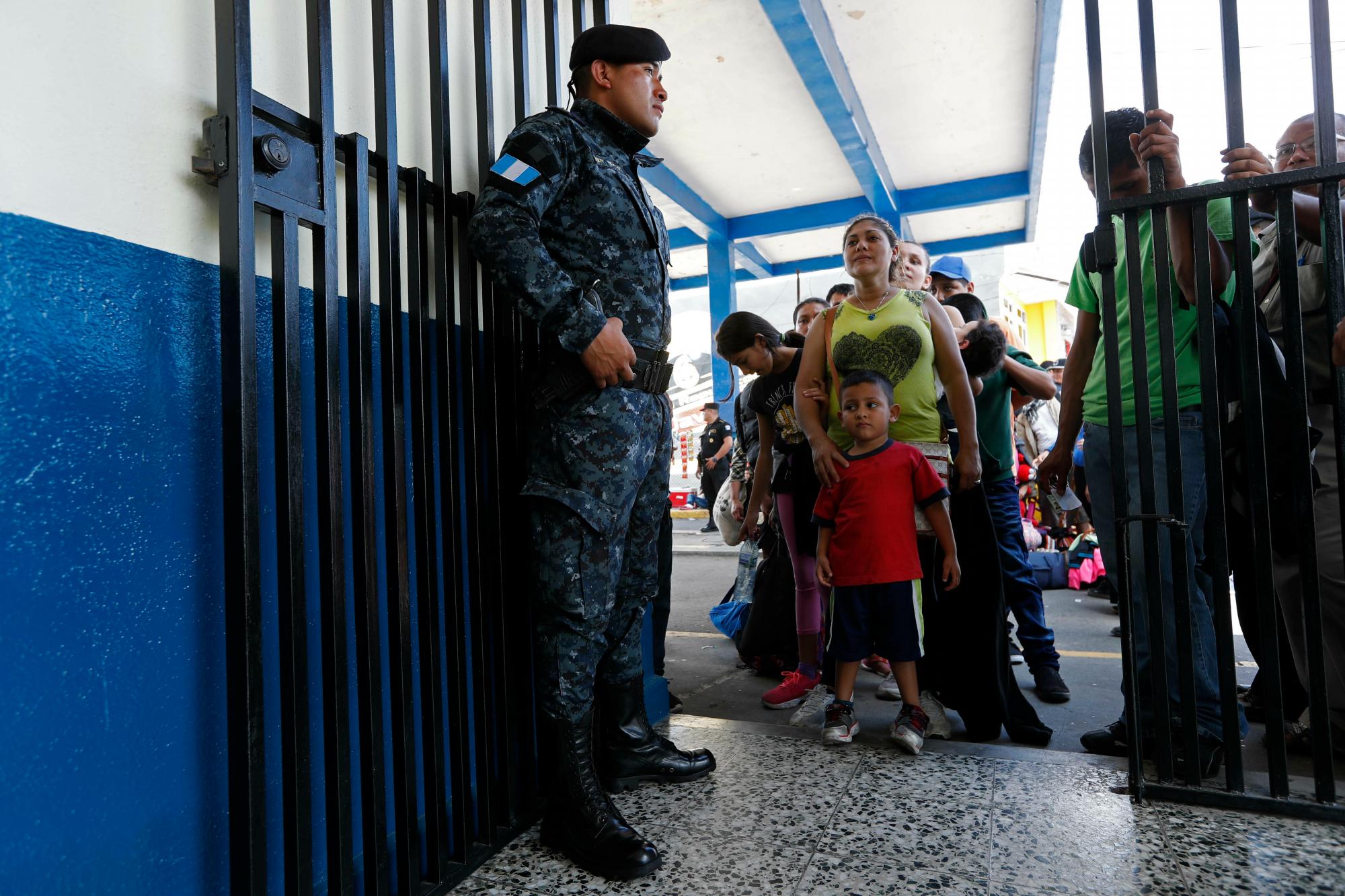 Los migrantes hondureños esperan que se verifiquen sus identificaciones y el permiso para cruzar la frontera en Tecun Uman, Guatemala, en la frontera con México, jueves 17 de enero de 2019. Cientos de migrantes hondureños son parte de una nueva caravana que busca llegar a los Estados Unidos.