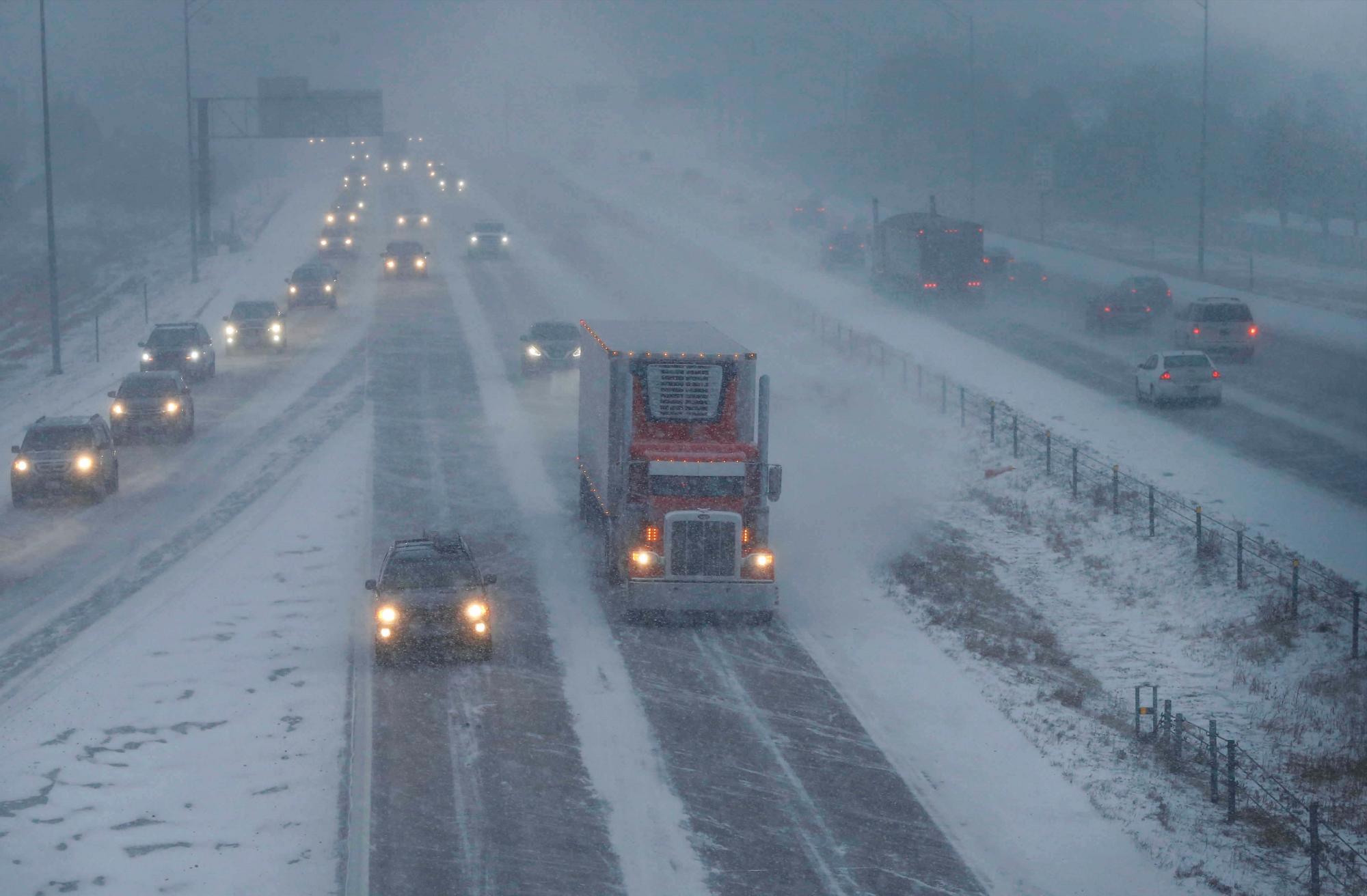 Los vehículos viajan a lo largo de la carretera interestatal 80 cuando cae una fuerte nevada, el viernes 18 de enero de 2019, en West Des Moines, Iowa.