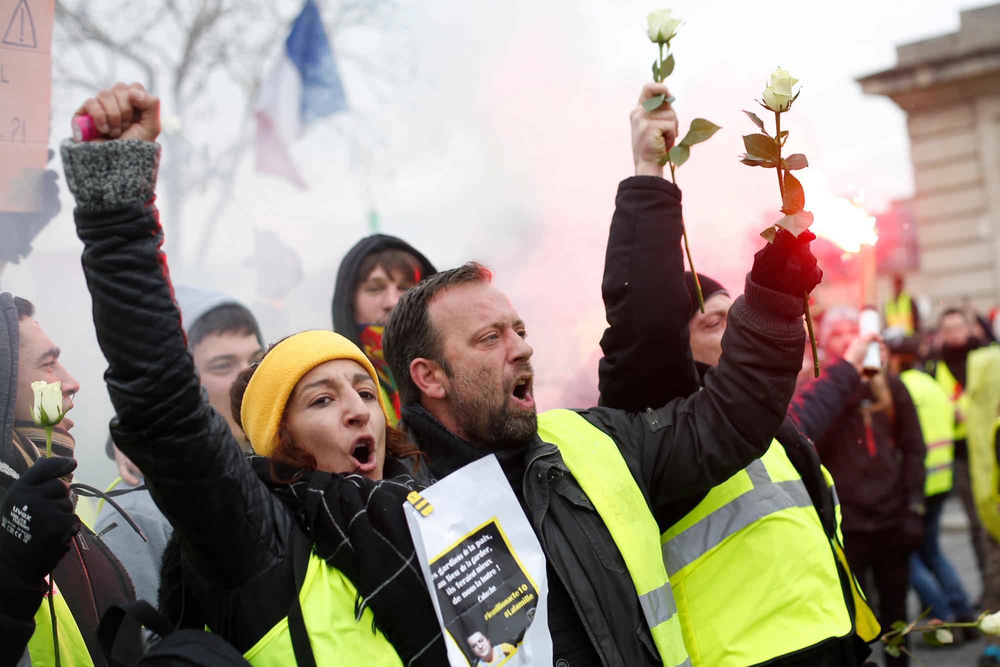 Los manifestantes del chaleco amarillo sostienen rosas blancas durante una marcha el sábado 19 de enero de 2019 en París. Los manifestantes del chaleco amarillo están planeando mítines en varias ciudades francesas a pesar del debate nacional iniciado esta semana por el presidente Emmanuel Macron con el objetivo de aplacar su ira.