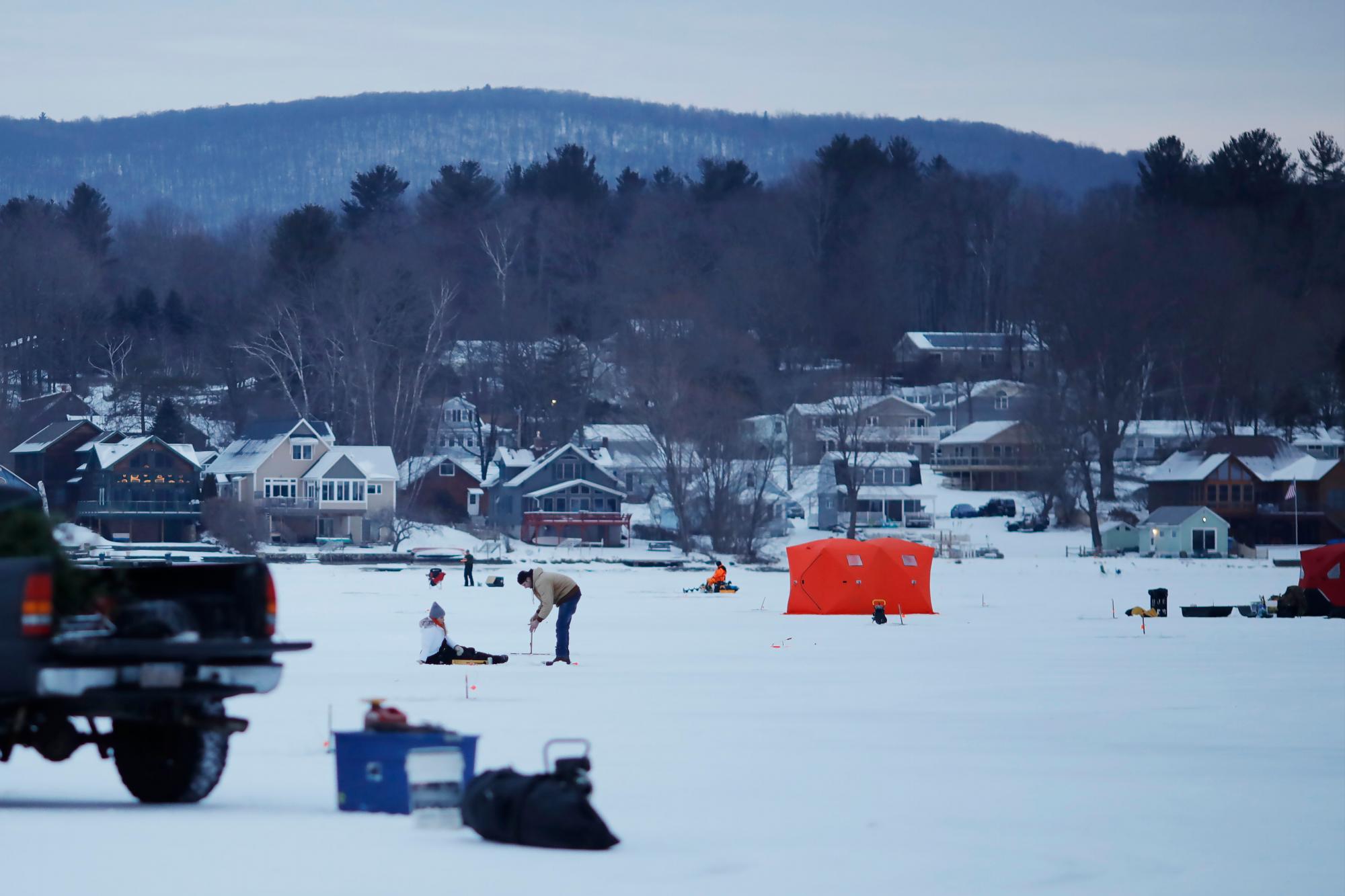 A medida que amanece sobre el lago Pontoosuc en Pittsfield, Massachusetts, el derby de pesca en el hielo está muy avanzado el sábado 19 de enero de 2019. Una tormenta de invierno avanza lentamente hacia Nueva Inglaterra después de verter la nieve y desacelerar los viajes de los residentes del Medio Oeste y Nueva York. Estados llanos.