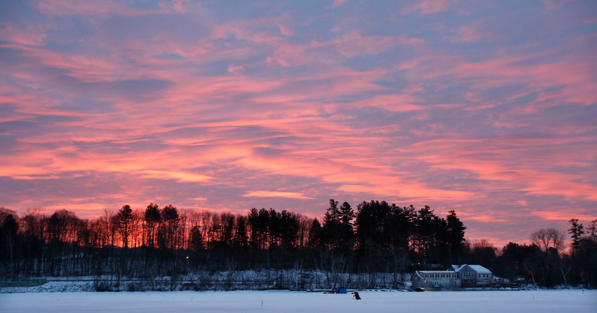 A medida que amanece sobre el lago Pontoosuc en Pittsfield, Massachusetts, el derby de pesca en el hielo está muy avanzado el sábado 19 de enero de 2019. Una tormenta de invierno avanza lentamente hacia Nueva Inglaterra después de verter la nieve y desacelerar los viajes de los residentes del Medio Oeste y Nueva York. 