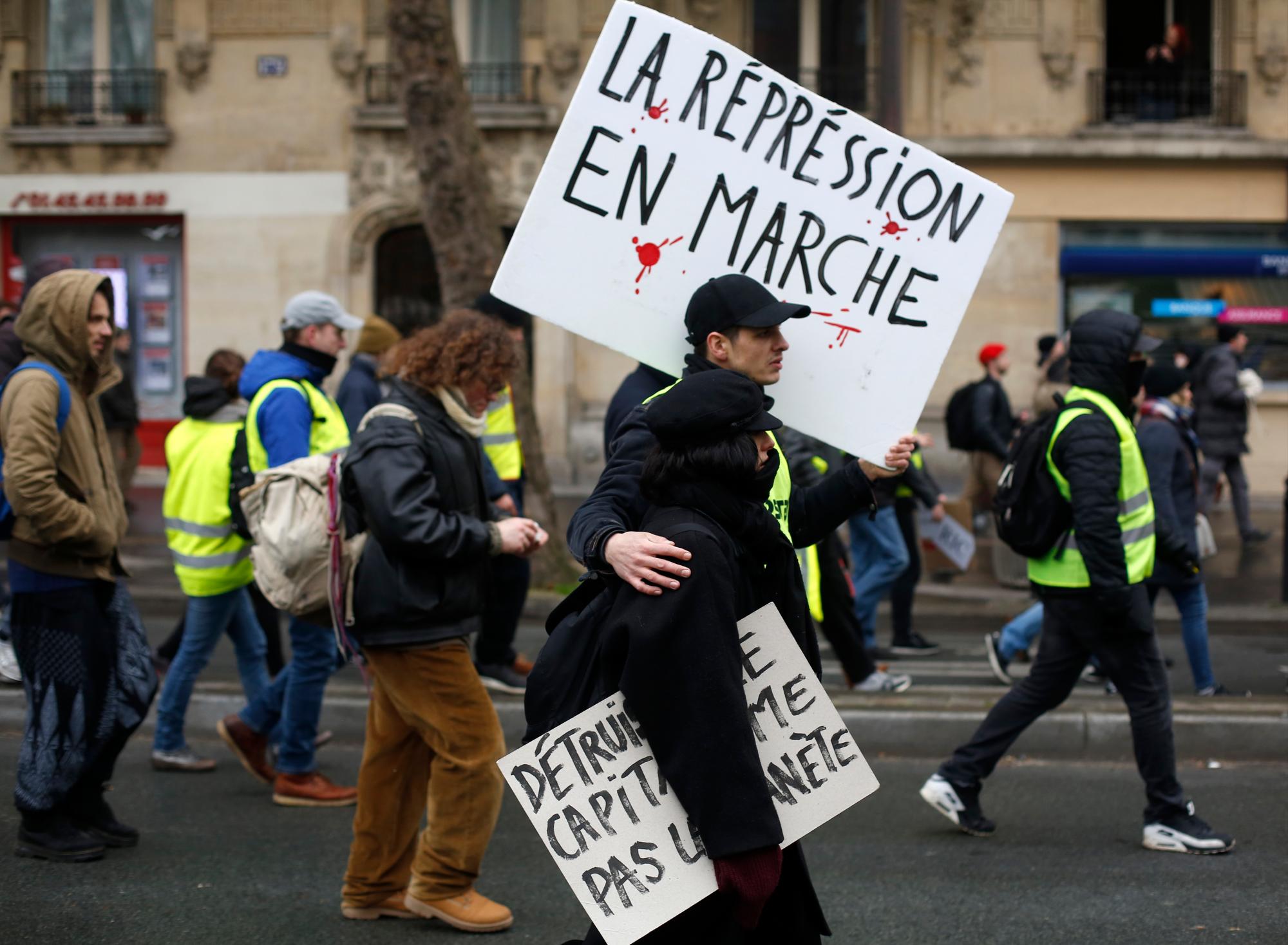 Los manifestantes del chaleco amarillo marchan con un cartel que dice “La represión continúa” durante una marcha el sábado 19 de enero de 2019 en París. Miles de manifestantes de chalecos amarillos se congregaron en varias ciudades francesas por décimo fin de semana consecutivo el sábado, a pesar del debate nacional iniciado esta semana por el presidente Emmanuel Macron con el objetivo de mitigar su ira.