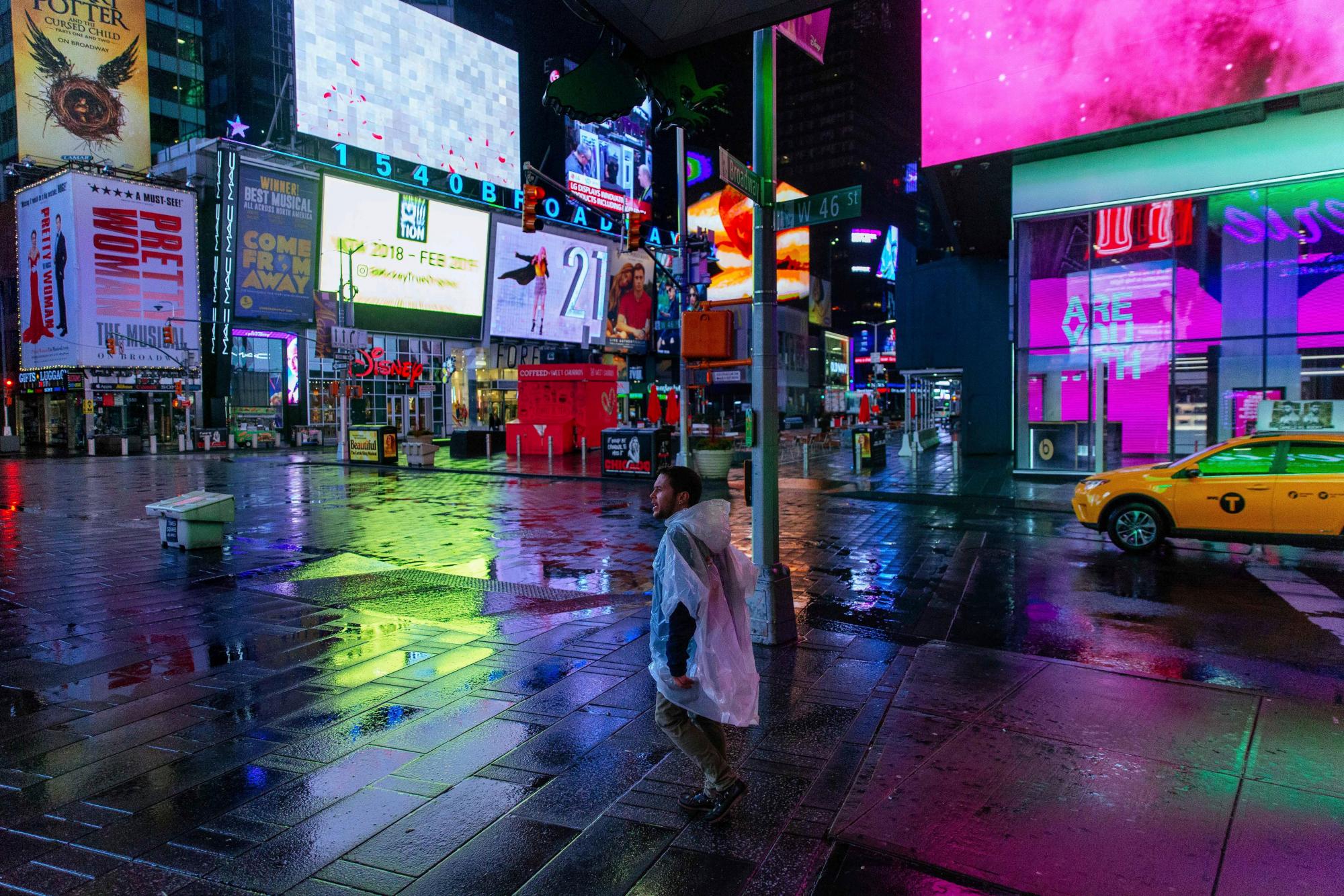 Un hombre que llevaba un poncho de plástico camina por Times Square en la madrugada del domingo, 20 de enero de 2019, en Nueva York. El Servicio Meteorológico Nacional dijo el sábado que una dramática caída de las temperaturas podría convertir la precipitación del fin de semana en hielo antes del lunes. 