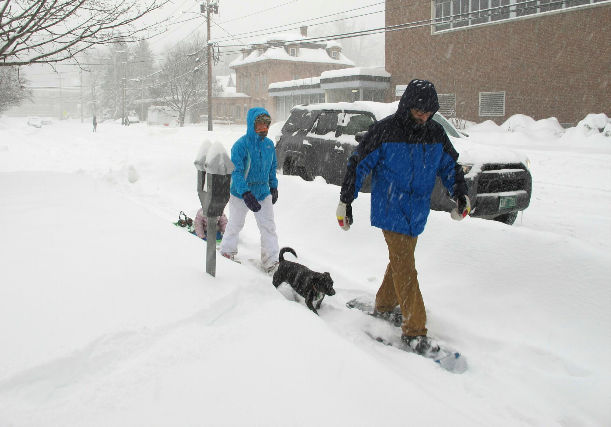 Will Roberts y su esposa Julia Chafets Snowshoe en el centro de Montpelier, VT., durante una tormenta de nieve el domingo, 20 de enero, 2019. Chafets está tirando de un trineo llevando a su hija.