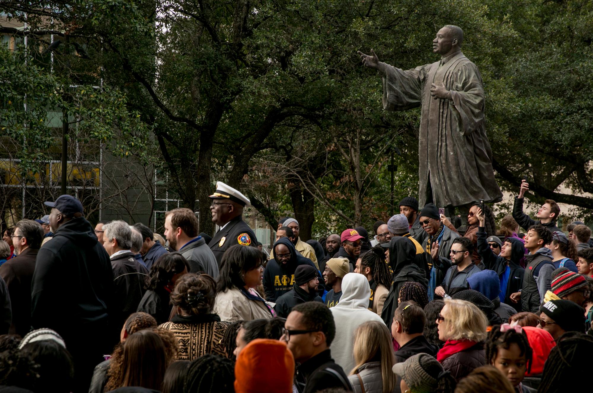 La gente escucha los discursos durante la marcha y el festival de MLK el lunes 21 de enero de 2019 en Austin, Texas. Miles conmemoraron el legado del asesinado líder de los derechos civiles, el Reverendo Martin Luther King Jr., en una marcha desde la Universidad de Texas hasta un festival comunitario en la Universidad de Houston-Tillotson.