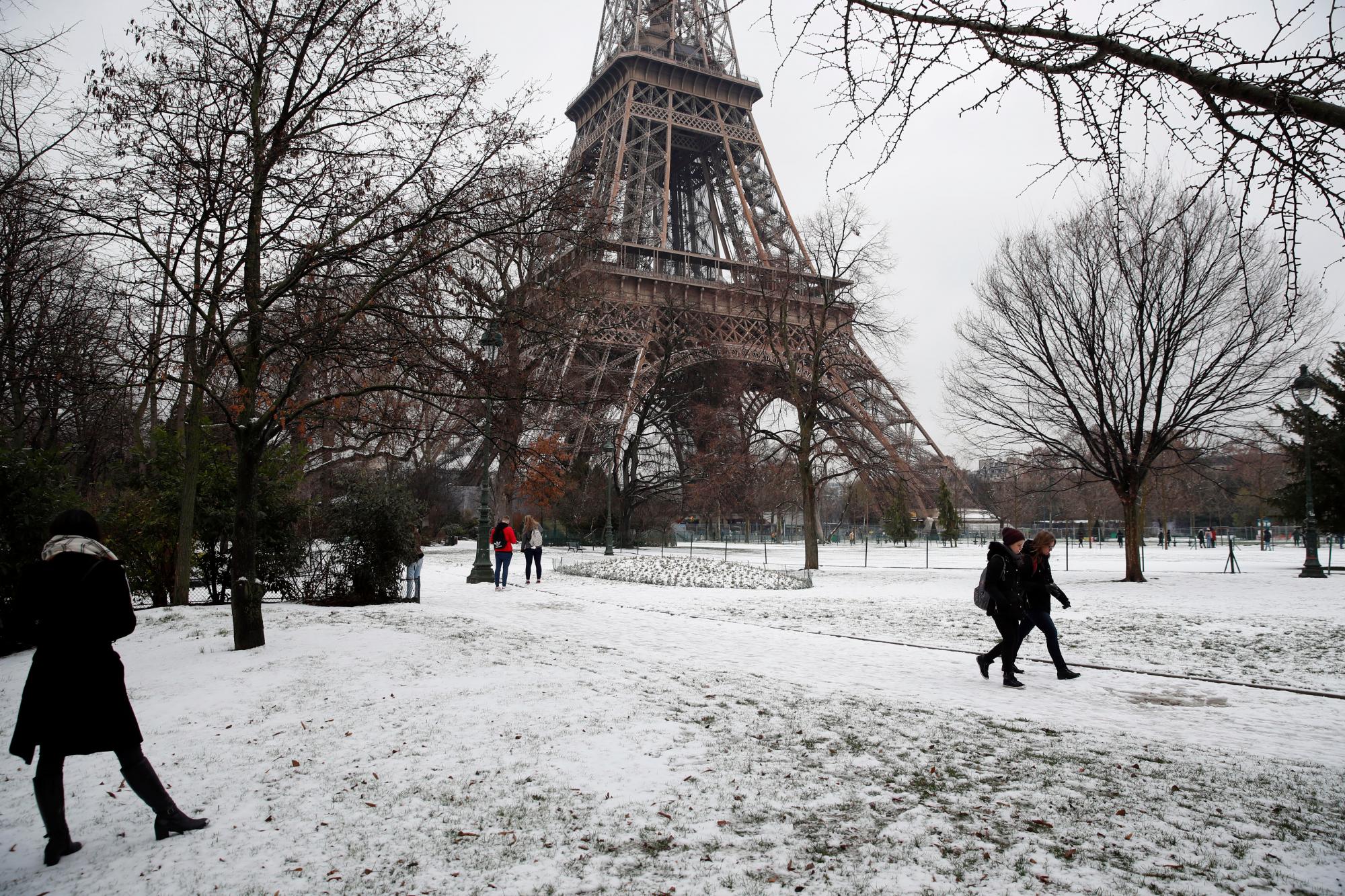 La gente pasa por delante de la Torre Eiffel, cerrada como medida de precaución, en París, el martes 22 de enero de 2019. La agencia meteorológica nacional de Francia, Meteo,  dice que una gran parte del país está en alerta por los peligrosos niveles de nieve y hielo e instó a la gente a que  limiten  su movimiento.