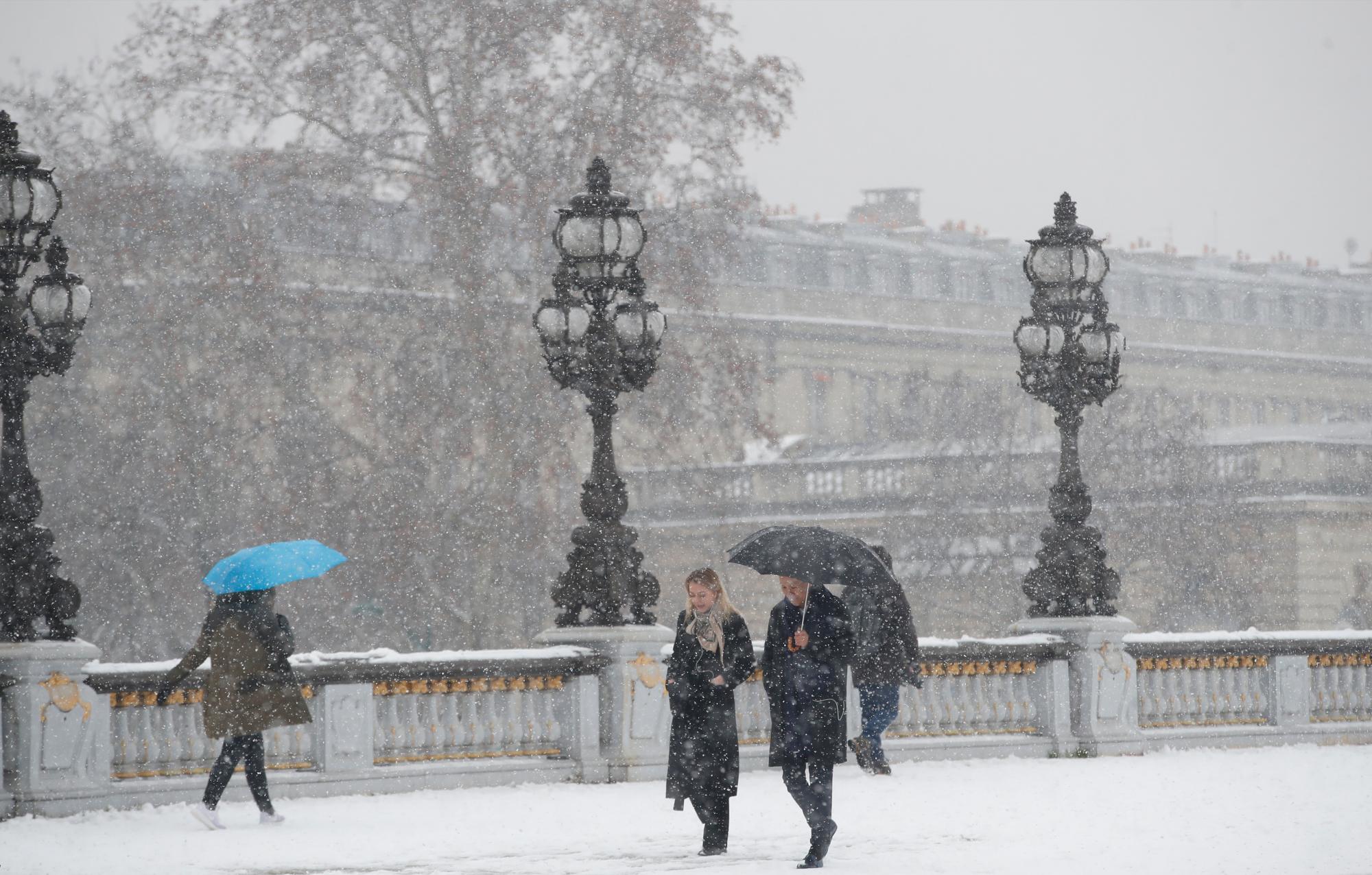 La gente cruza el puente Alexandre III en París, el martes 22 de enero de 2019. La agencia meteorológica nacional de Francia, Meteo,  dice que una gran parte del país está en alerta por niveles peligrosos de nieve y hielo e instó a las personas a limitar su movimiento. 