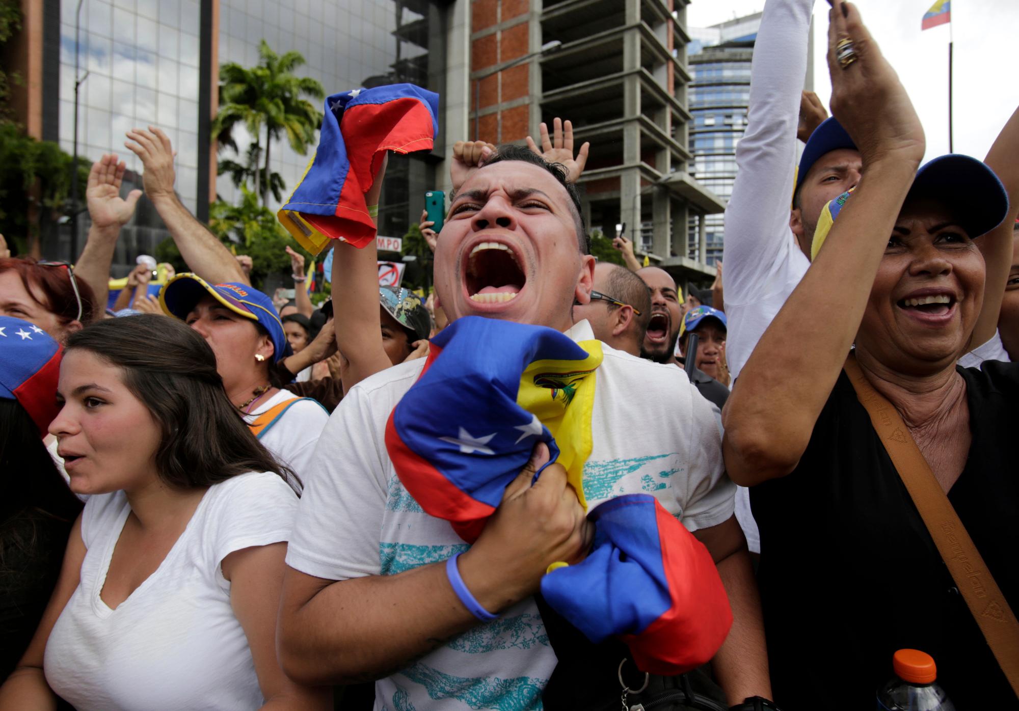 Los manifestantes antigubernamentales aplauden a Juan Guaido, jefe del congreso de oposición de Venezuela, que se declara presidente interino del país sudamericano hasta que se pueda convocar una nueva elección, en un mitin que exige la renuncia del presidente Nicolás Maduro en Caracas, Venezuela, el miércoles 23 de enero de 2019.