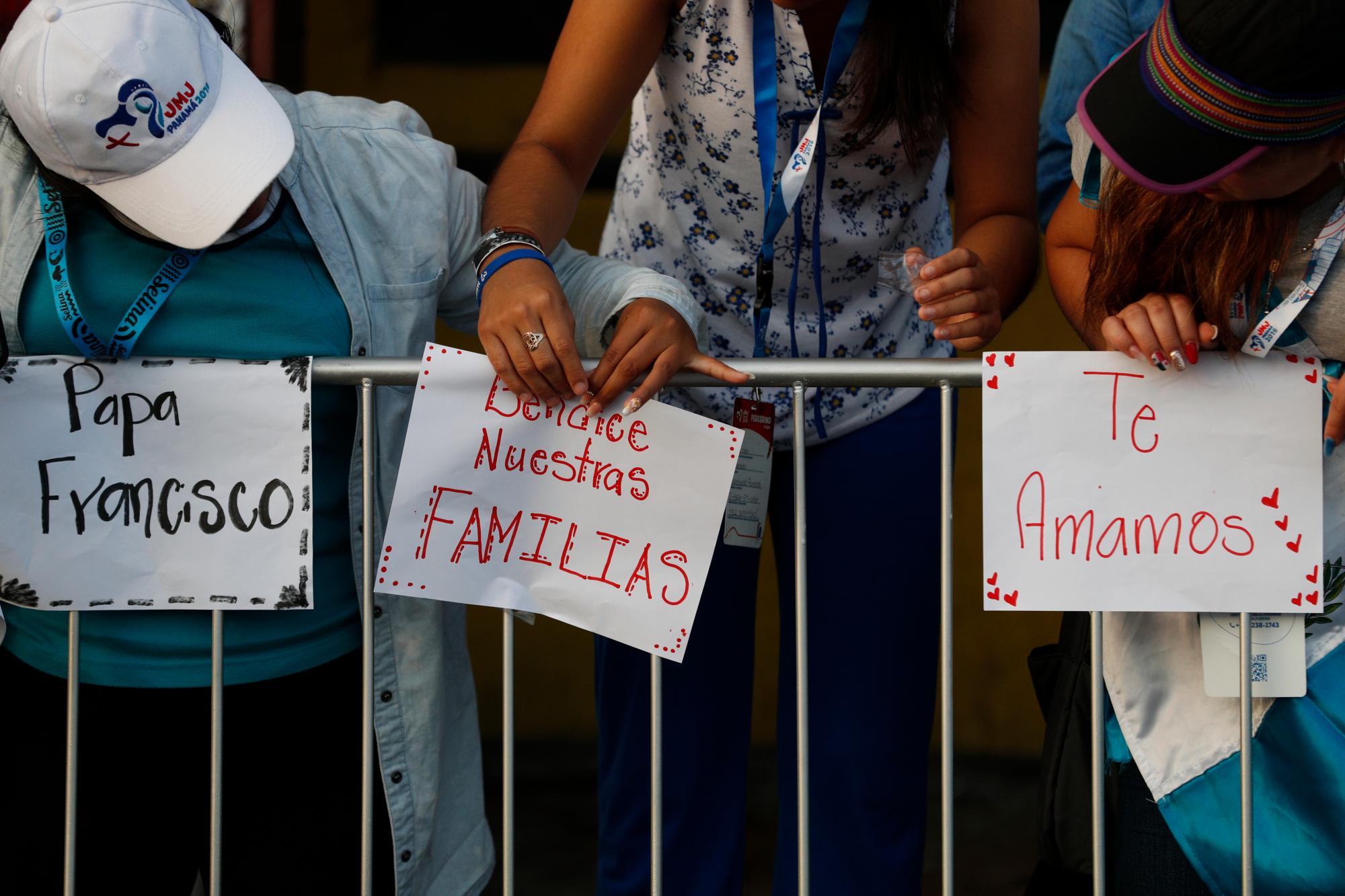 Los peregrinos guatemaltecos escriben mensajes de bienvenida en la barrera de la multitud mientras esperan que el Papa Francisco pase por delante del palacio presidencial, en la ciudad de Panamá.