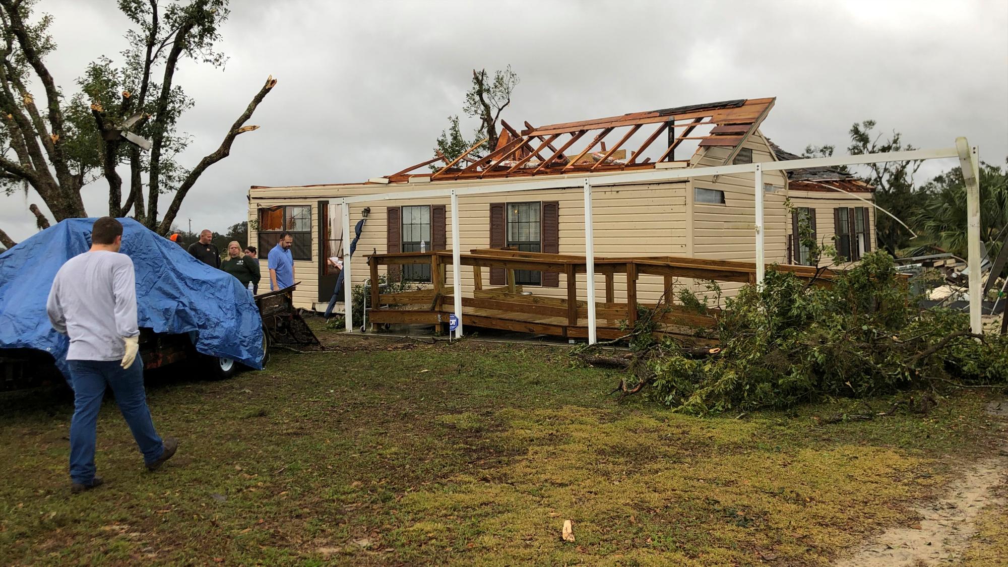 Los residentes observan el daño luego de que casas y propiedades dañadas por el clima severo en Mascotte, Florida, el jueves 24 de enero de 2019. Las autoridades dicen que un posible tornado dañó varias casas y derribó árboles y líneas eléctricas cuando una línea de tormentas cruzó el centro de Florida. 