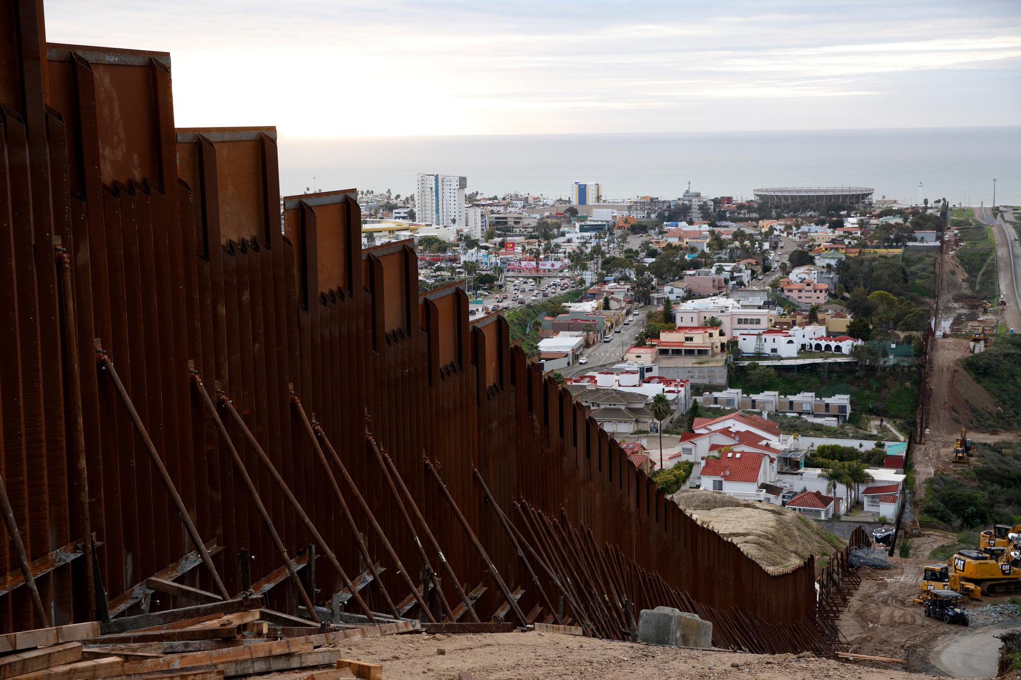 Una sección de muro fronterizo recién reemplazado separa Tijuana, México de San Diego.