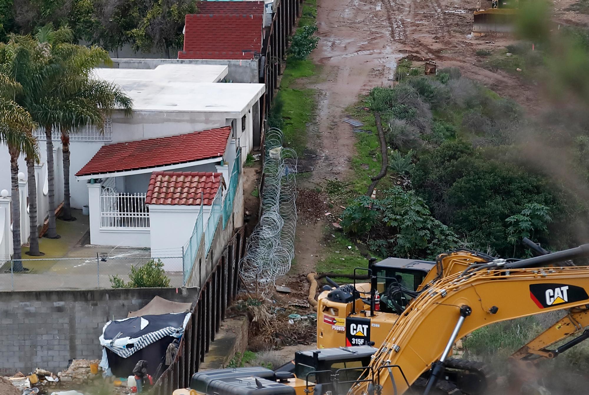  Estructuras en Tijuana, México, a la izquierda de la sección más antigua del muro fronterizo, ya que la maquinaria está preparada para continuar el reemplazo de la pared por nuevas secciones, en San Diego. Funcionarios de la patrulla fronteriza dicen que algunas casas y estructuras mexicanas invaden el suelo de Estados Unidos y plantean un dilema para las autoridades cuando reemplazan la pared.