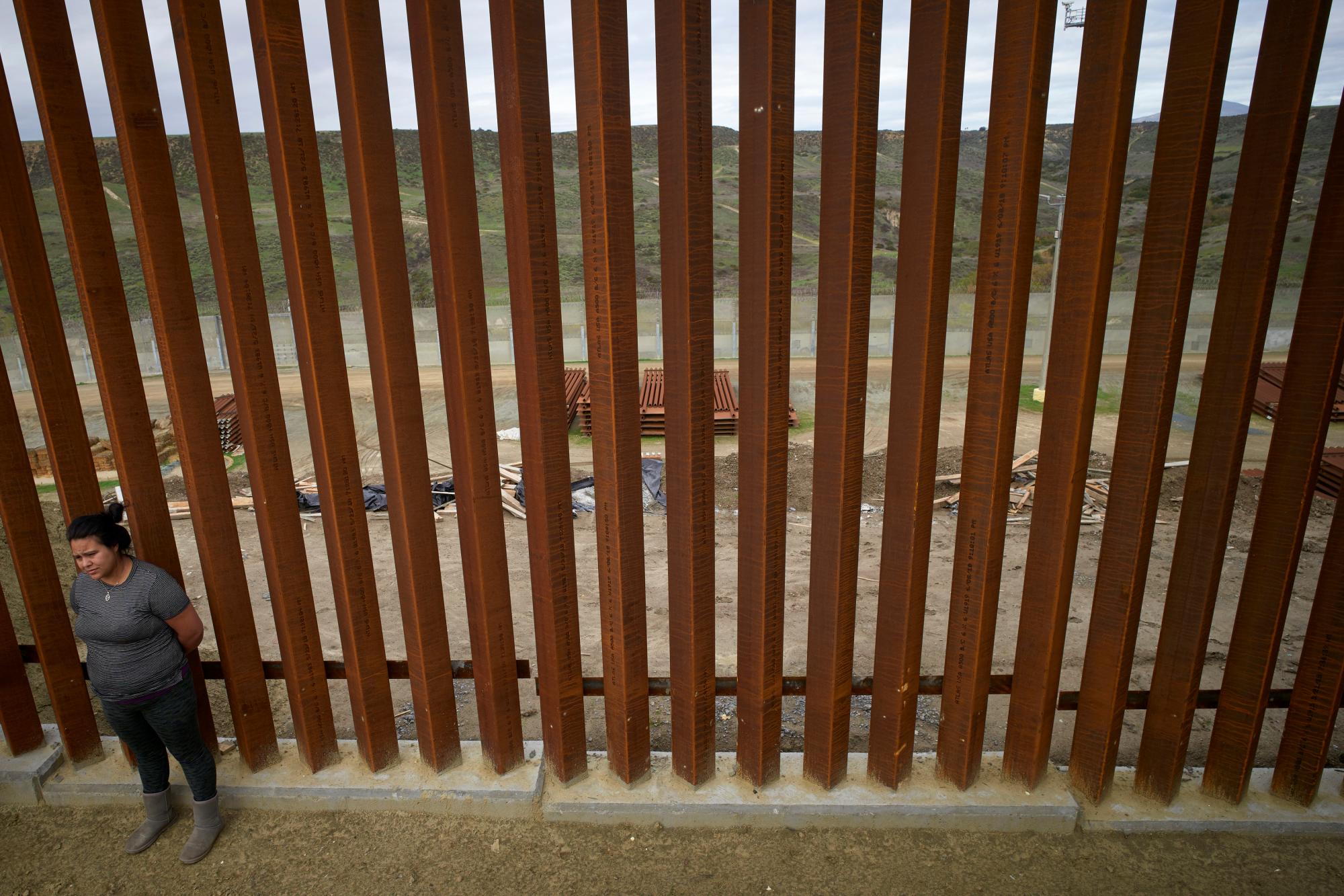  Yuli Arias, se encuentra frente a una nueva sección de muro fronterizo que se encuentra en su vecindario en Tijuana, México. Estados Unidos se enfrenta a un baile delicado, ya que traza un curso para extender o reemplazar barreras fronterizas cerca de casas y estructuras.