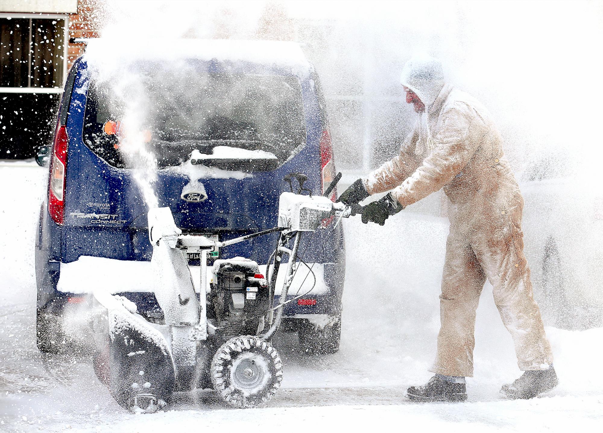 El empleado de Holiday Inn & Suites John Mills despeja la nieve del estacionamiento del hotel en la Crosse, Wisconsin, después de una tormenta durante la noche cubrió la región. 