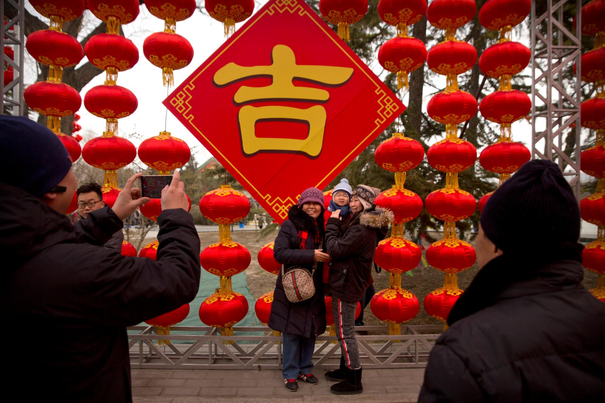 La gente posa para fotos frente a un muro de linternas en una feria del templo en Longtan Park en Beijing, el miércoles 6 de febrero de 2019. Los chinos celebran el segundo día del Año Nuevo Lunar el martes, el año del cerdo del zodiaco chino.