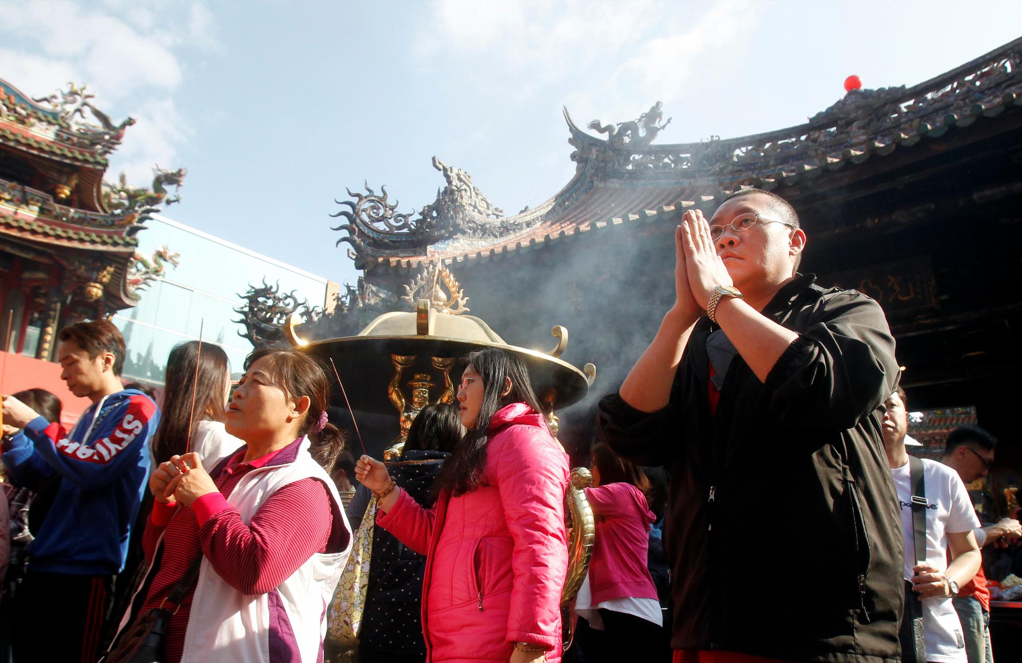 La gente reza en el popular Templo Longshan para el Año Nuevo Chino, Año del Cerdo, en Taipei, Taiwán, el miércoles 6 de febrero de 2016. 
