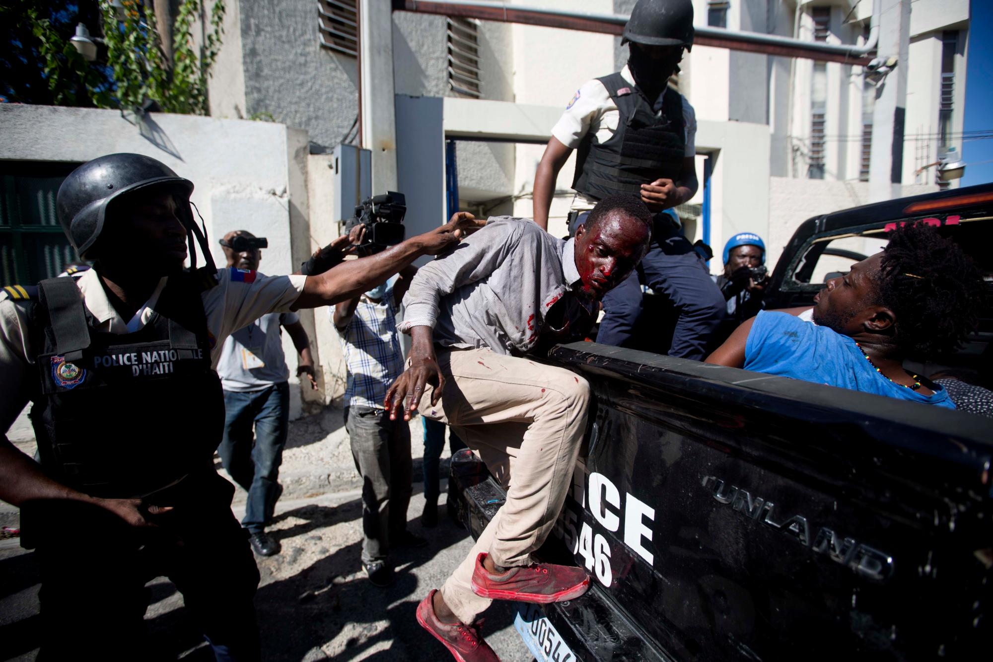 Varios hombres son detenidos por agentes de la Policía Nacional luego de que fueron encontrados saqueando un Banco Nacional de Crédito, durante una protesta para exigir la renuncia del Presidente Jovenel Moïse en Puerto Príncipe, Haití.