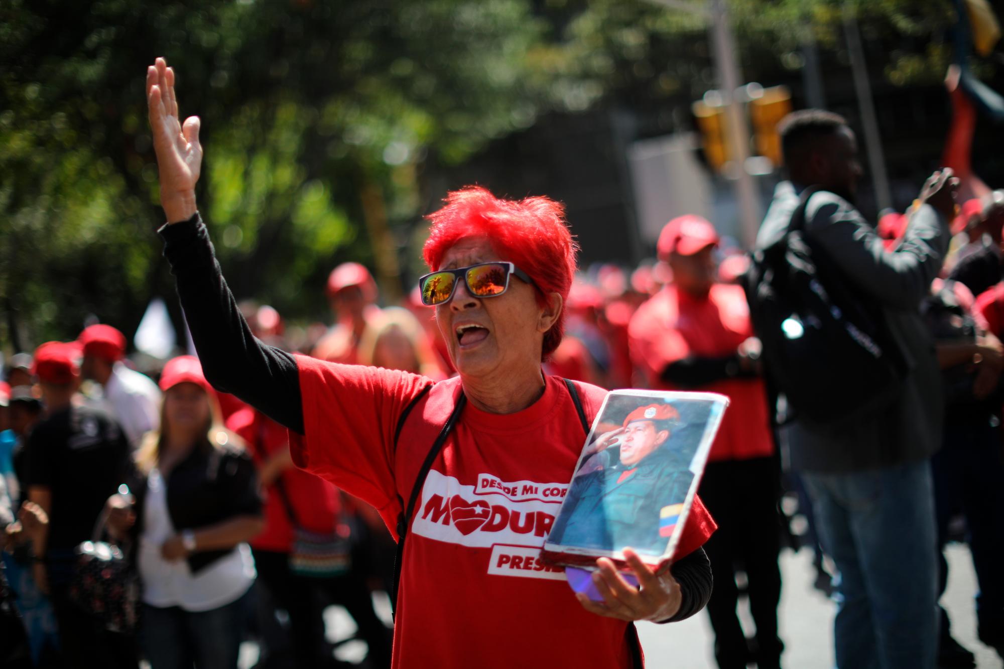 Un simpatizante del presidente de Venezuela, Nicolás Maduro, sostiene una foto del fallecido presidente de Venezuela, Hugo Chávez, durante una manifestación oficialista en Caracas, Venezuela.