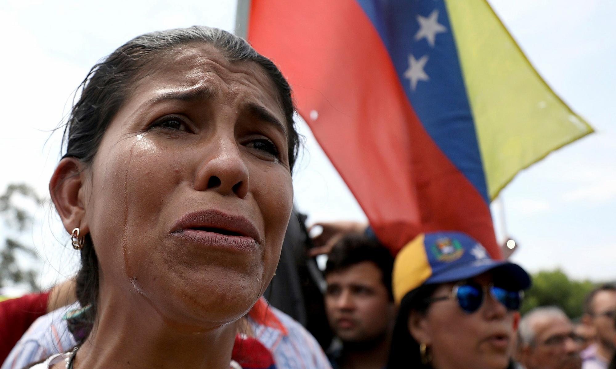 La inmigrante venezolana Yanela Aleman llora mientras canta su himno nacional en la parada, cerca de Cúcuta, Colombia, en la frontera con Venezuela.