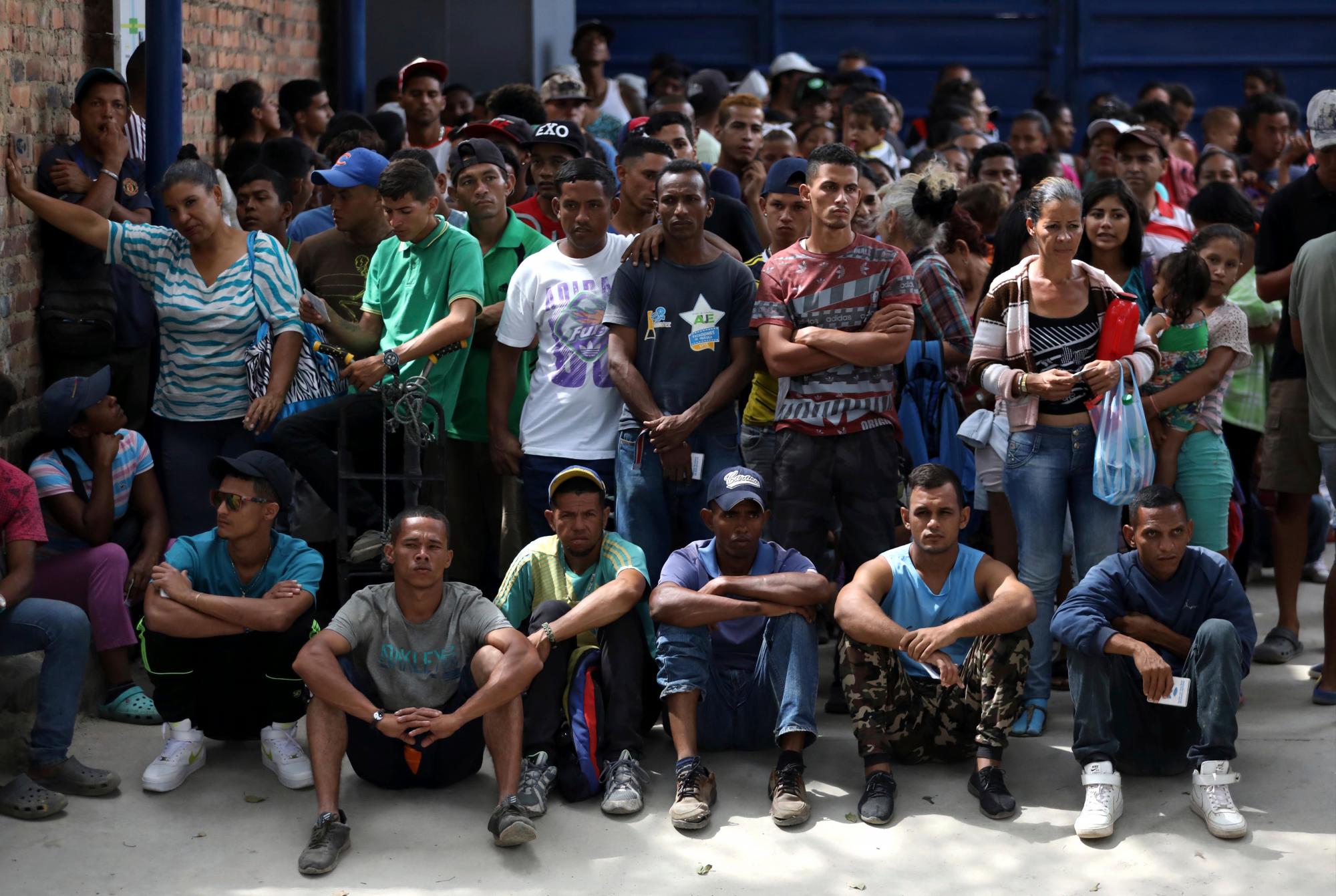 Migrantes venezolanos esperan por su almuerzo en el refugio.