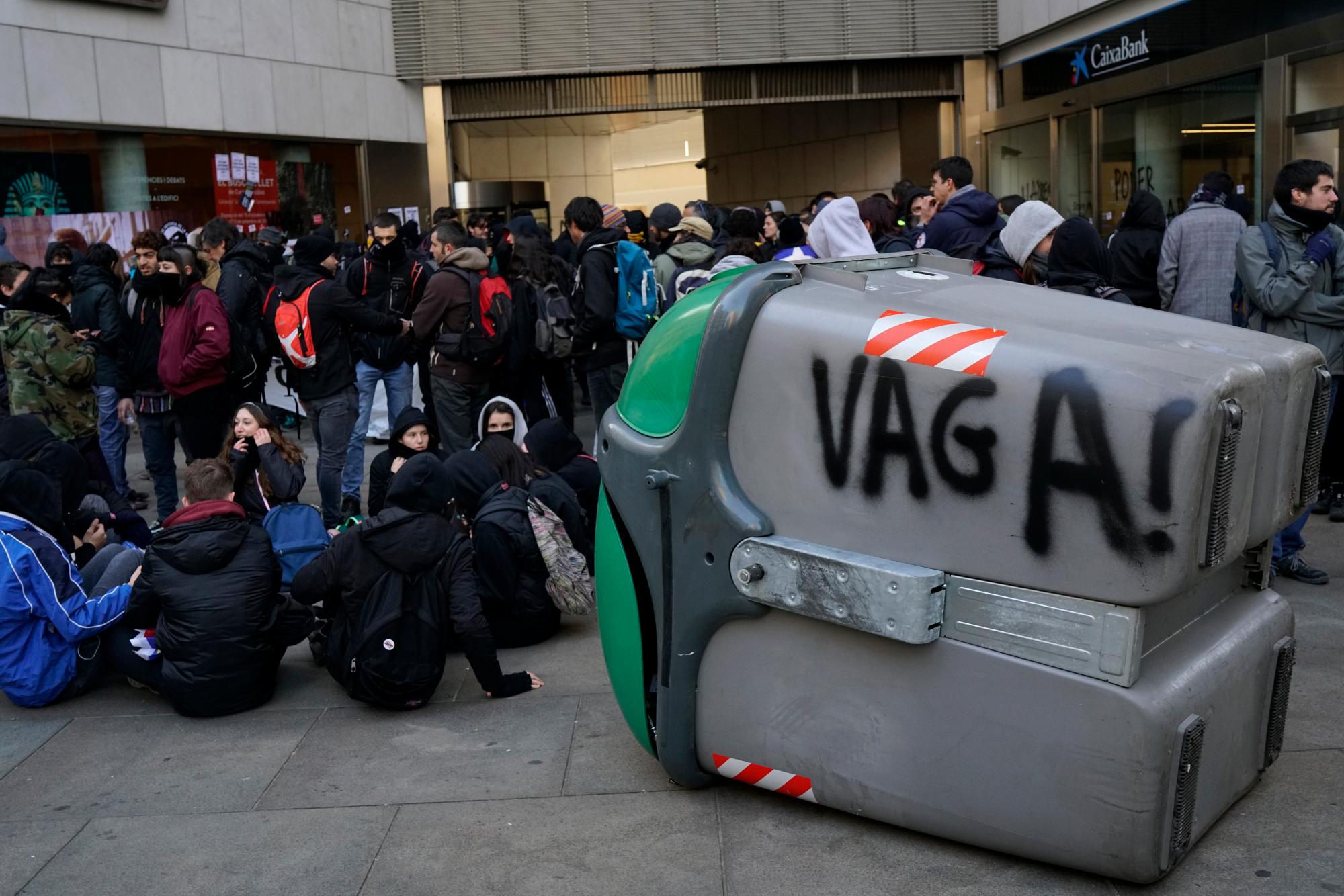 Los manifestantes se reúnen durante una huelga general en Cataluña, en Girona, España, el jueves 21 de febrero de 2019, con un graffiti en zafacón que dice “huelga”. Los huelguistas que abogan por la secesión de Cataluña de España están bloqueando las principales autopistas, líneas de tren y carreteras en toda la región noreste.