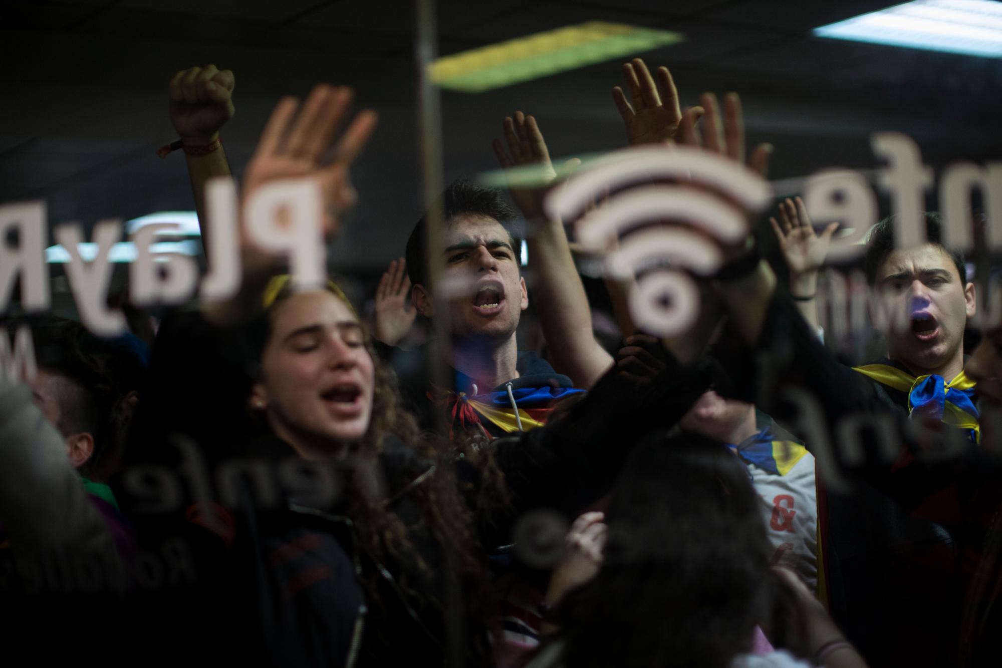 Los manifestantes intentan ingresar a un tren subterráneo para bloquear un tren durante una huelga general en Cataluña, España, el jueves 21 de febrero de 2019.