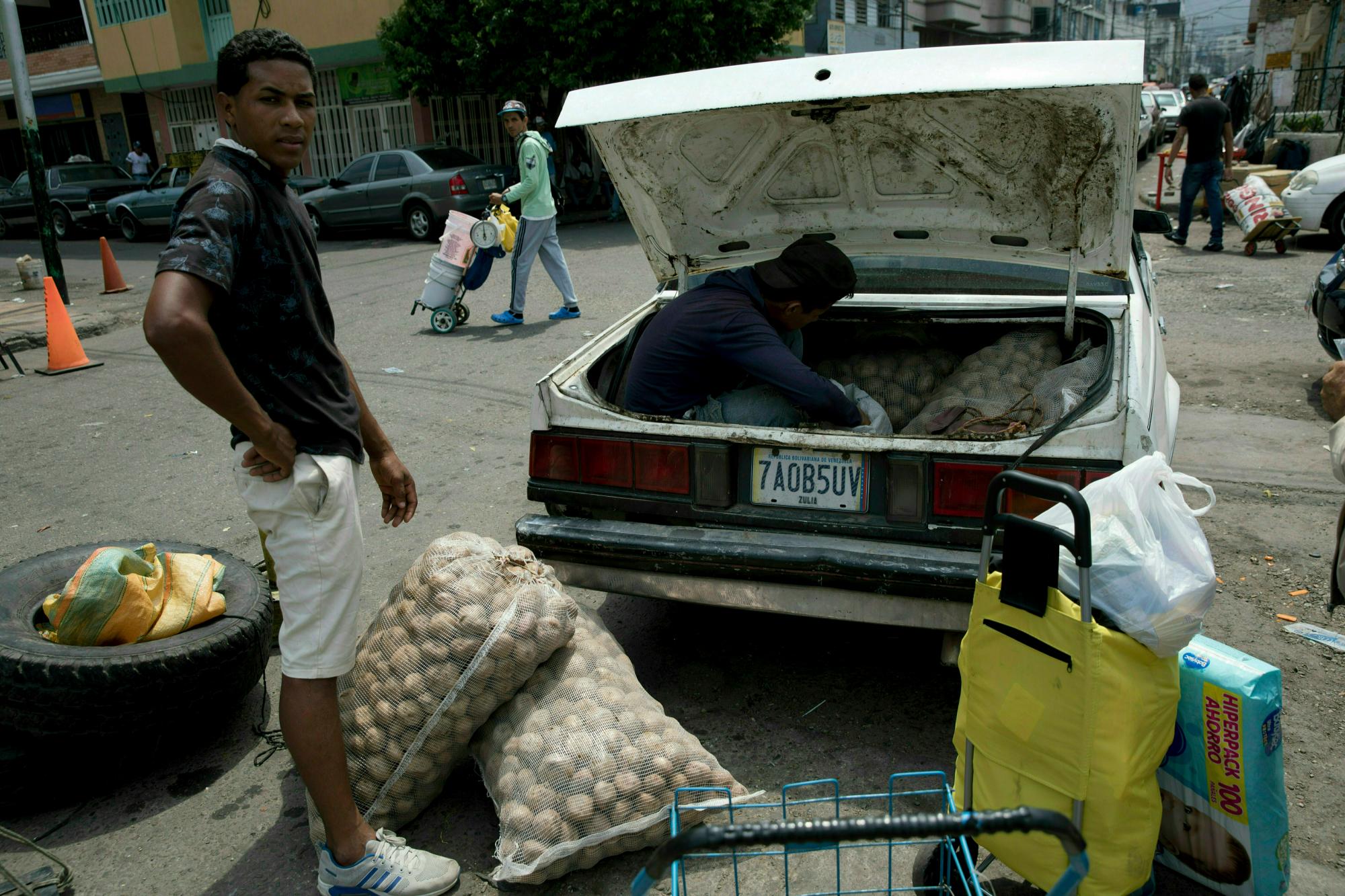 Un hombre carga su automóvil con papas compradas en Colombia, en San Antonio del Táchira, Venezuela, en la frontera con Colombia, el jueves 21 de febrero de 2019.