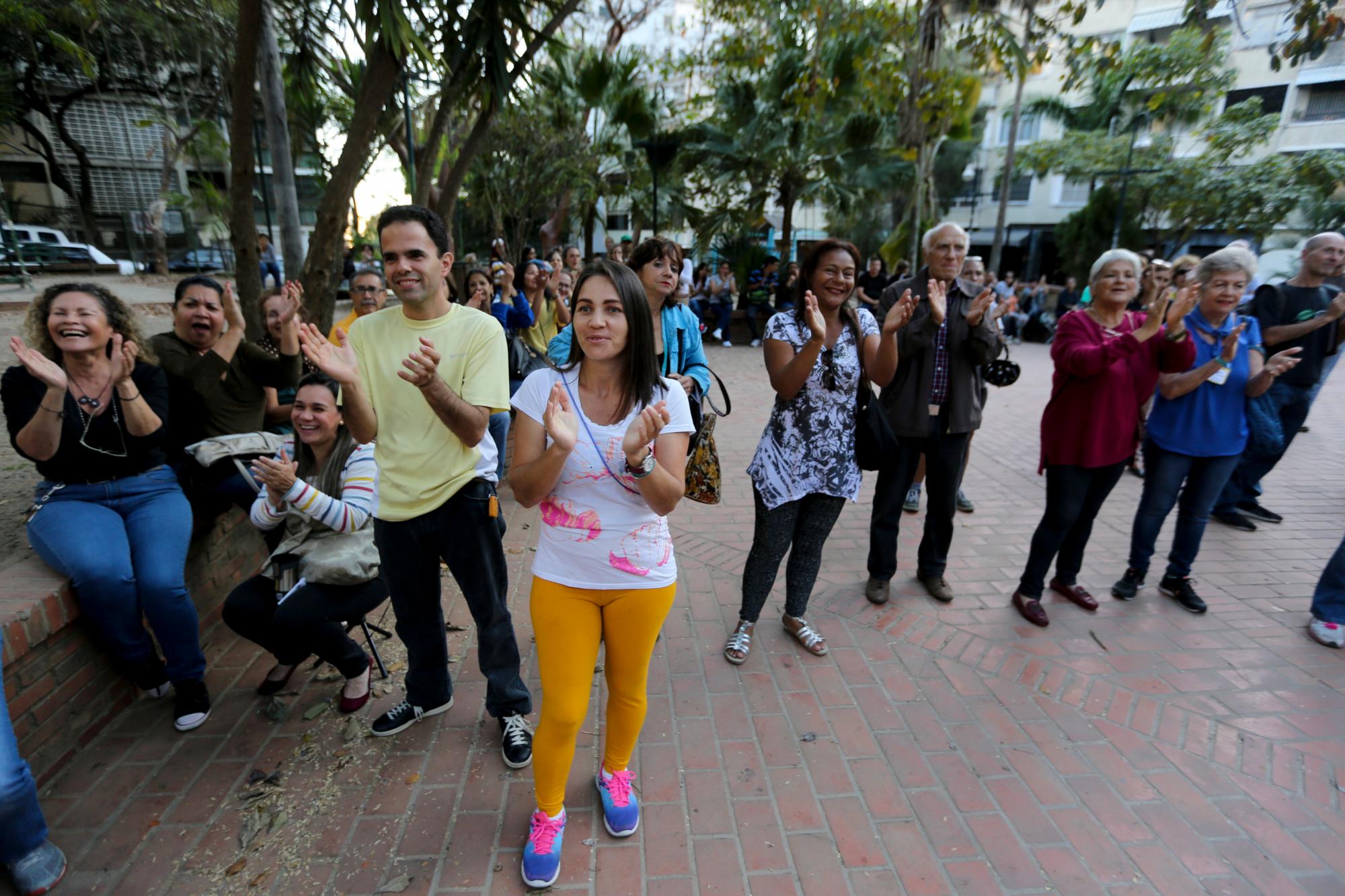 Voluntarios aplauden durante una reunión de reclutamiento en una plaza de Caracas, Venezuela. 