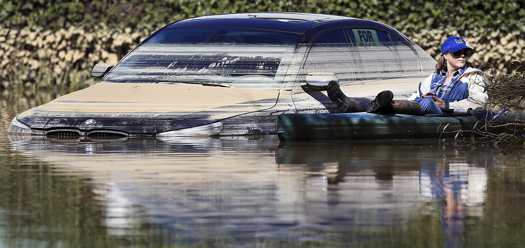 El agua de la inundación en Guerneville, California, comienza a retroceder dejando atrás los recordatorios del nivel mientras el residente de Guerneville, Janice Rojas, se relaja en su kayak, el 28 de febrero de 2019.