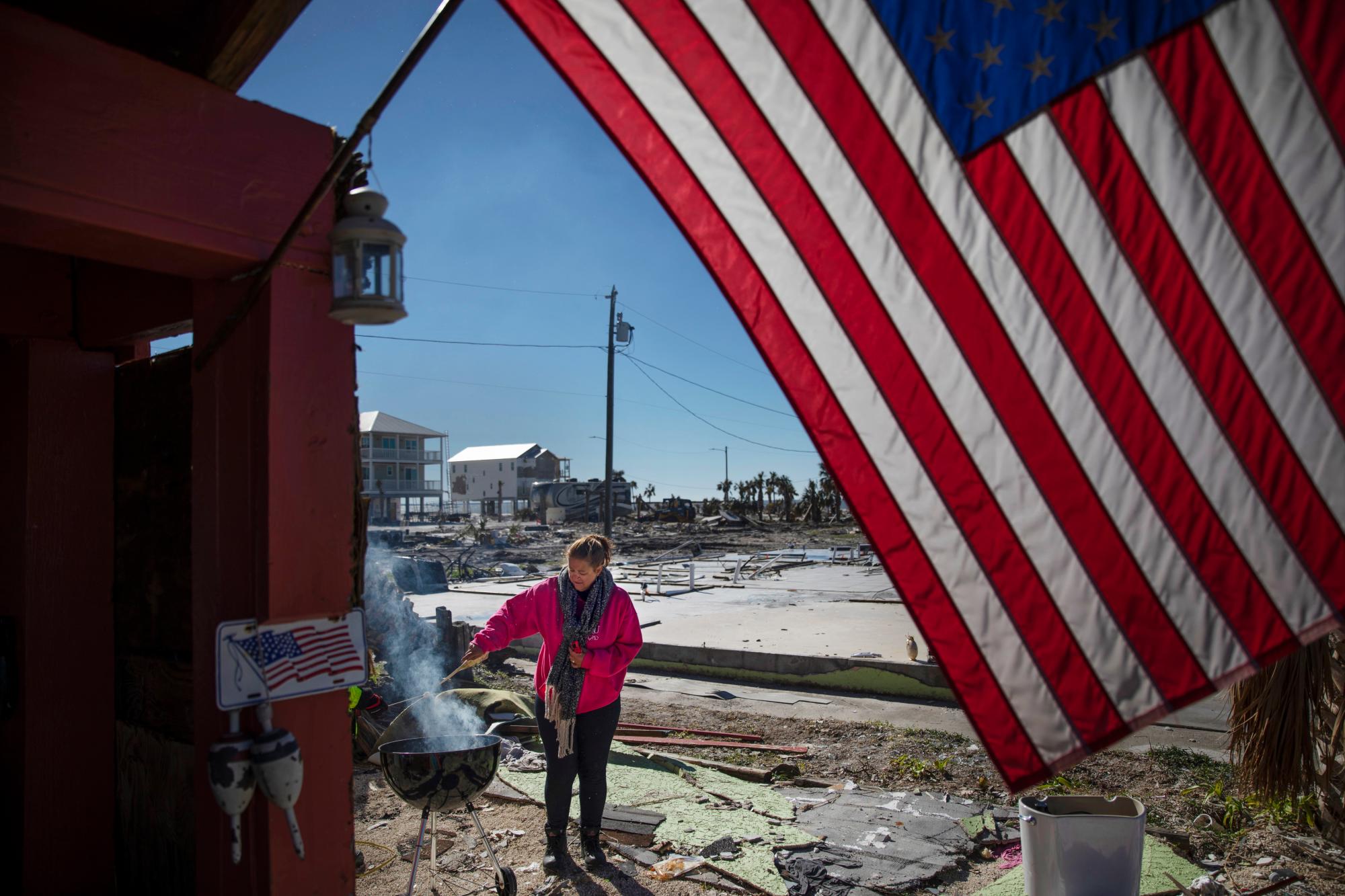 Paulina Bela Sebastiao enciende una barbacoa mientras espera a que su casa dañada por el huracán Michael sea demolida en Mexico Beach, Florida, el viernes 25 de enero de 2019. 