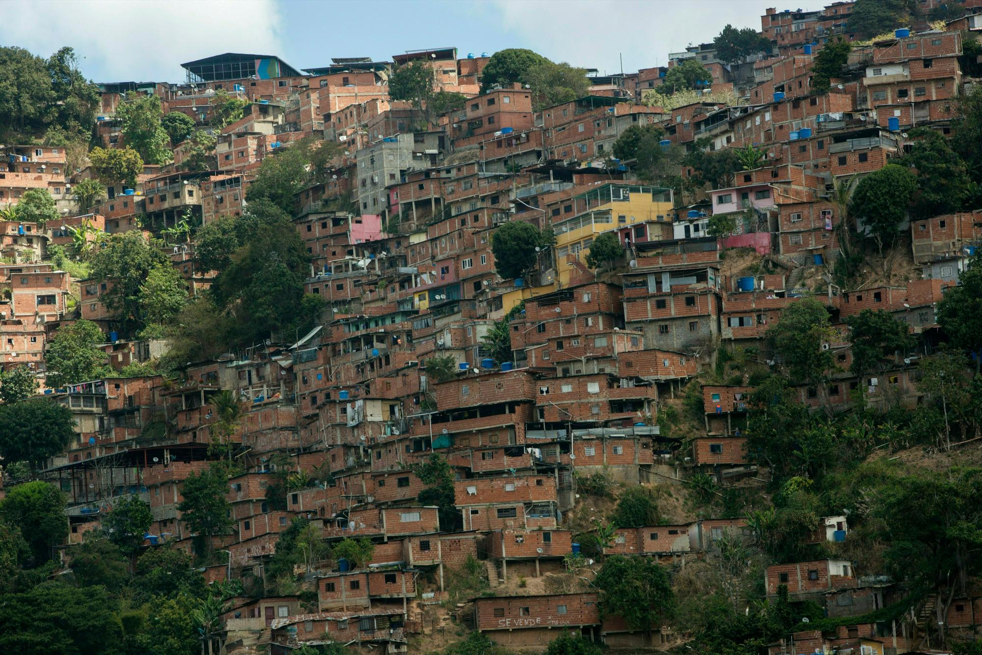 Esta foto del 14 de febrero de 2019 muestra una parte de Petare Shanty Town, uno de los barrios marginales más grandes de América Latina, en Caracas, Venezuela. Unas 400,000 personas viven en la multitud de casas de bloques de colores brillantes que cubren las laderas de Caracas hasta donde alcanza la vista.