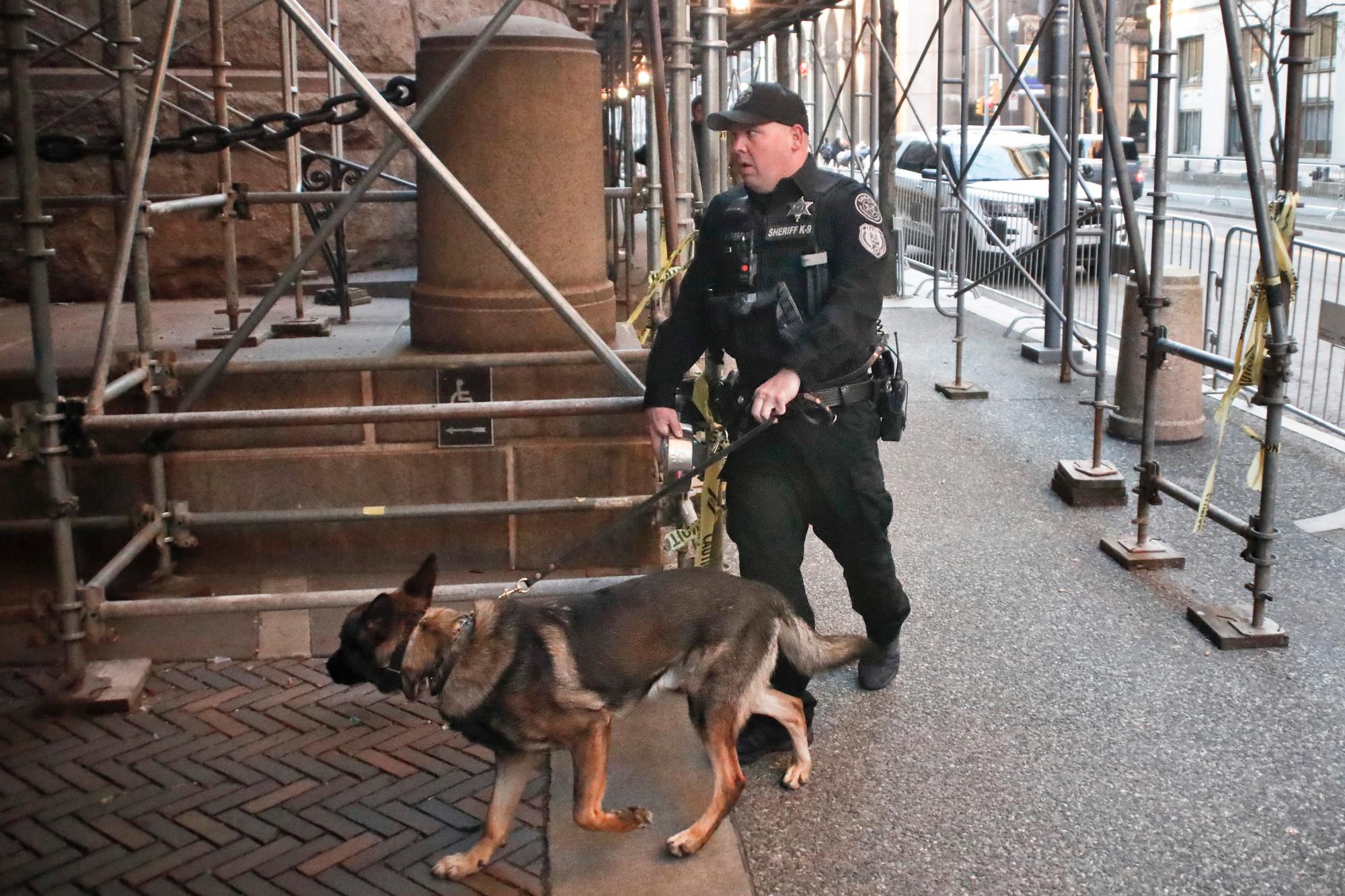 Un agente de policía del Condado de Allegheny Sherriff entra, junto a un perro,  en el Juzgado del Condado de Allegheny   en el primer día del juicio para Michael Rosfeld, un ex oficial de policía en East Pittsburgh, PA., el martes, 19 de marzo de 2019, en Pittsburgh.